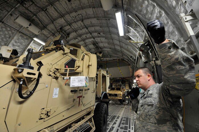 Staff Sgt. Nicholas Reddin acts as a clearance spotter while a Mine-Resistant, Ambush-Protected Armored All Terrain vehicle is loaded onto a  C-17 at Charleston AFB Sept. 30. The MATVs are specialized transport vehicles designed to handle the rugged terrain of Afghanistan. Sergeant Reddin is an air transport specialist with the 437th Aerial Port Squadron. (U.S. Air Force photo/James M. Bowman)