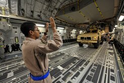 Senior Airman Robert Clark marshals a Mine-Resistant, Ambush-Protected All Terrain vehicle onto a C-17 at Charleston AFB Sept. 30. Airman Clark is a loadmaster with the 4th Airlift Squadron from McChord AFB, Wash. Two MATV's were airlifted to Afghanistan to support combat missions. (U.S. Air Force photo/James M. Bowman) 
