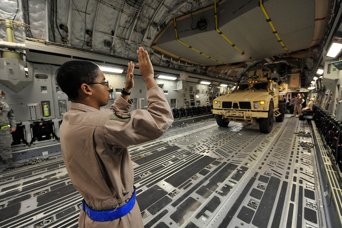 Senior Airman Robert Clark marshals a Mine-Resistant, Ambush-Protected All Terrain vehicle onto a C-17 at Charleston AFB Sept. 30. Airman Clark is a loadmaster with the 4th Airlift Squadron from McChord AFB, Wash. Two MATV's were airlifted to Afghanistan to support combat missions. (U.S. Air Force photo/James M. Bowman) 
