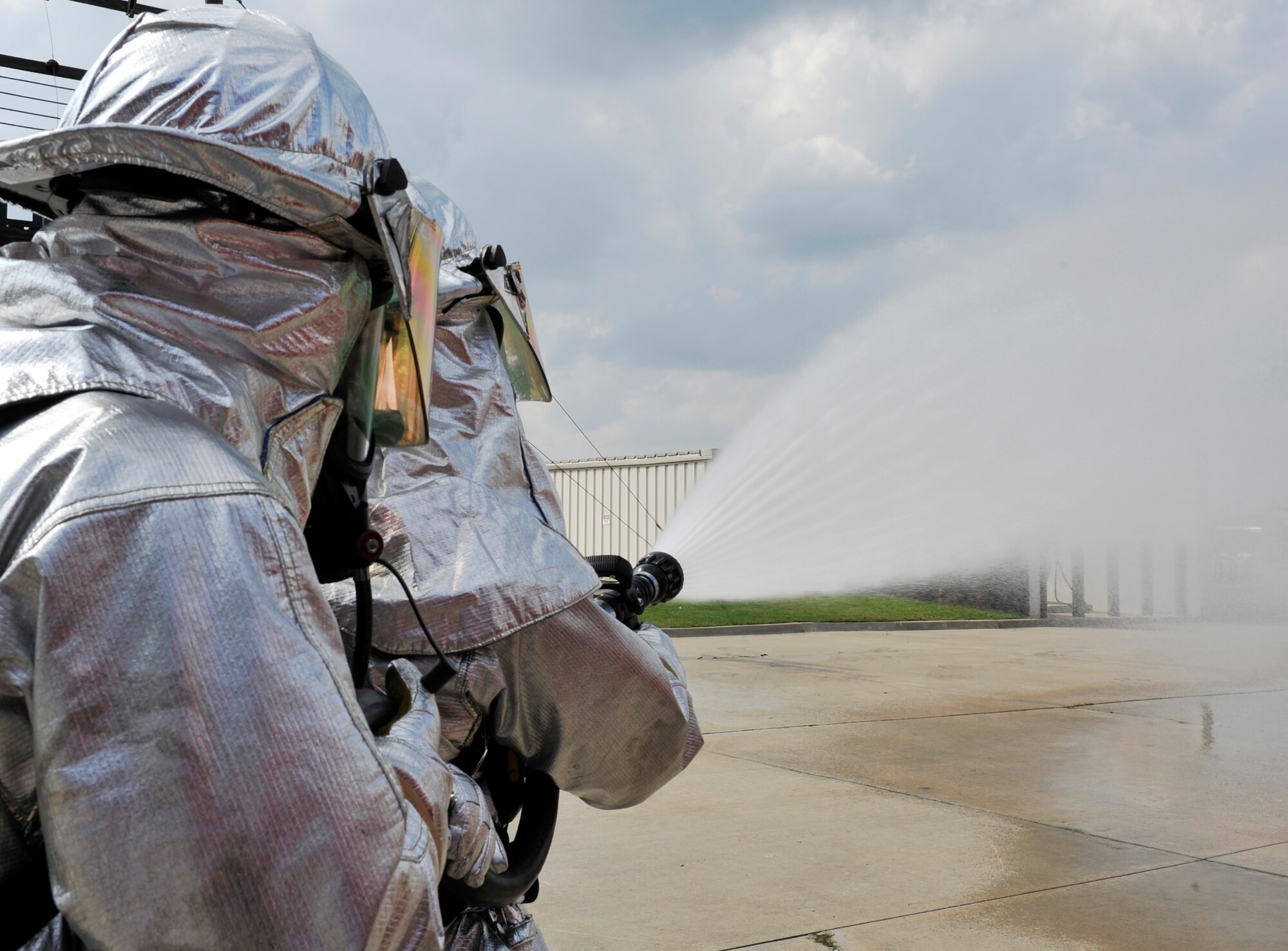 Airman 1st Class Marcus Lamorie (right) and Airman 1st Class Daniel O'Conner, 19th Civil Engineering Squadron fire fighters, simulate extinguishing a fire on the flight line Sept. 21. The P19 crash truck hose can discharge 60 gallons a minute. (U.S. Air Force photo by Airman 1st Class Lausanne Pacheco)