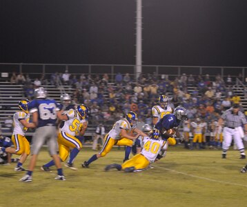 Randolph High School football player Andre Hamilton is tackled by Blanco High School defenders, during the game at Randolph High School football stadium. (U.S. photo by Joel Martinez)