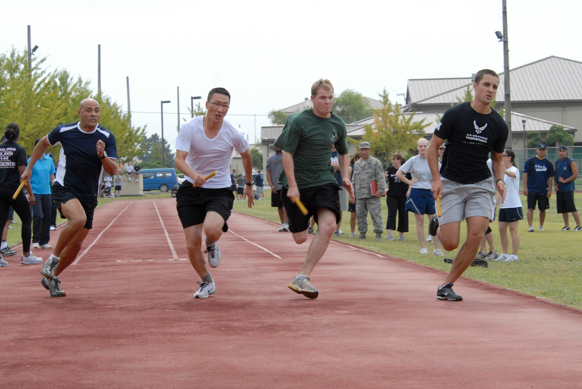 KUNSAN AIR BASE, Republic of Korea -- A Member from the 8th Medical Group team, Republic of Korea Air Force team, 8th Logistic Readiness Squadron team 2, and 8th Logistics readiness Squadron team 1 begin the 4x400 relay race during sports day Sept 29. This morale event had eight teams of four people racing in two heats with the top team from each race advancing to the championship race. (U.S. Air Force photo/Staff Sgt. Darnell T. Cannady)