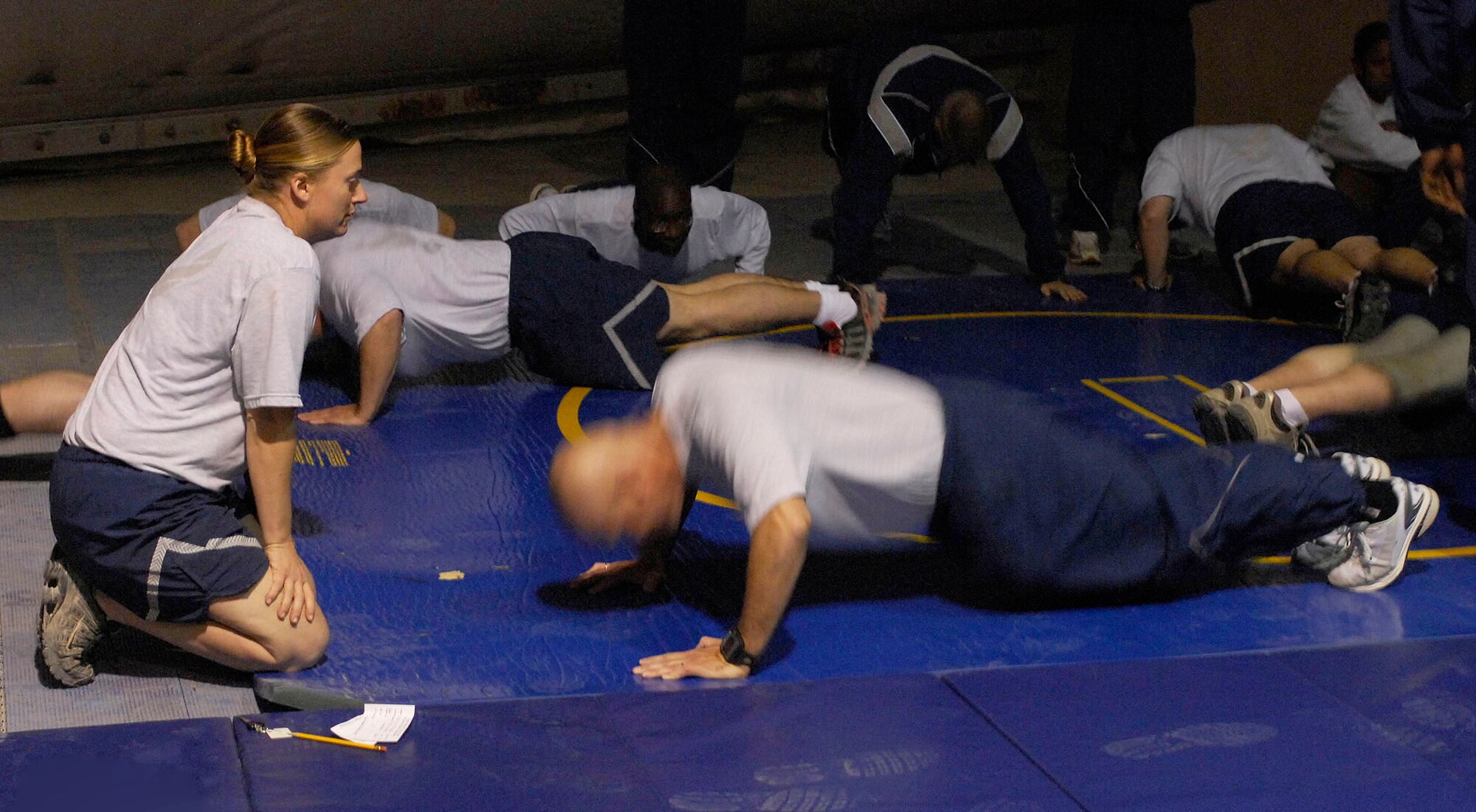 BAGRAM AIRFIELD, Afghanistan -- An Airman assigned to the 455th Air Expeditionary Wing watches her fellow Airman perform push-ups for a baseline physical fitness test here.  The test was not an official PT test, but rather something Gen. Steven Kwast, 455th AEW commander, wanted his Airmen to have so they could track their progress as they moved through their deployment. (U.S. Air Force photo/Tech. Sgt. John Jung)