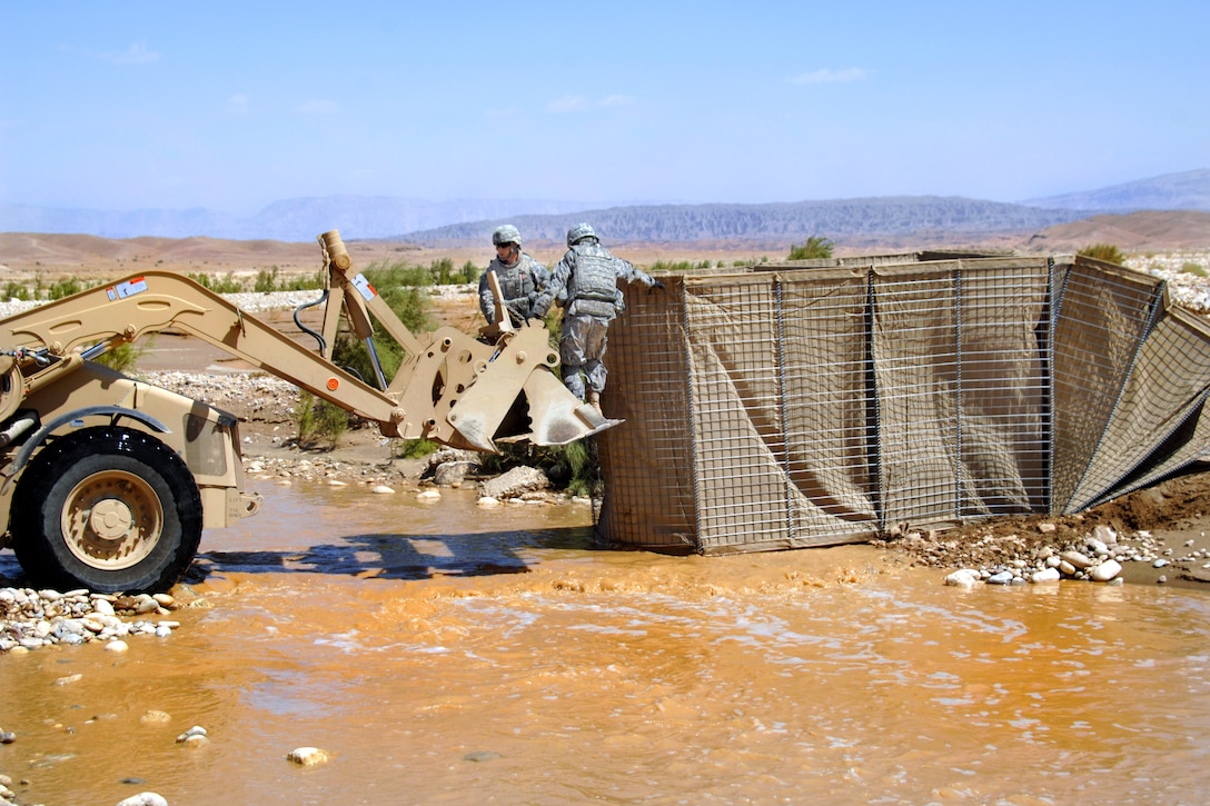 U.S. Army soldiers use a HESCO barrier to help create a ford over a river near the Iraq-Iran border, Iraq, Sept. 22, 2009. A bridge over a stream had been washed away by recent rains and the ford allows Military Transition Teams to conduct training with Iraqi border guards.