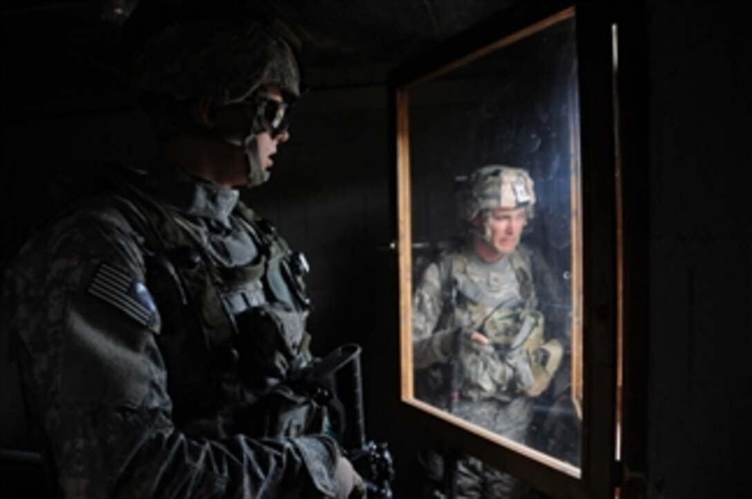 U.S. Army Pvt. Joseph Bosse (left) and Sgt. Michael Tardie look out through a window of a building they secured during a training exercise at Joint Multinational Readiness Center in Hohenfels, Germany, on Sept. 4, 2009.  Both soldiers belong to 1st Platoon, Bravo (Legion) Company, 1st Battalion, 503rd Infantry Regiment, 173rd Airborne Brigade Combat Team, U.S. Army Europe.  