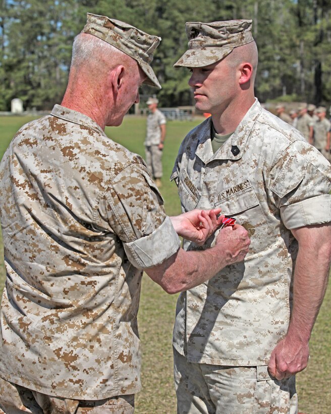 Master Sgt. Christopher W. Burrell, an amphibious assault vehicle crewman with Amphibious Assault Battalion, receives the Bronze Star medal on April 1, 2010, aboard Marine Corps Base Camp Lejeune, N.C. Presenting the medal is Maj. Gen. Richard T. Tryon, the commanding general of 2nd Marine Division.