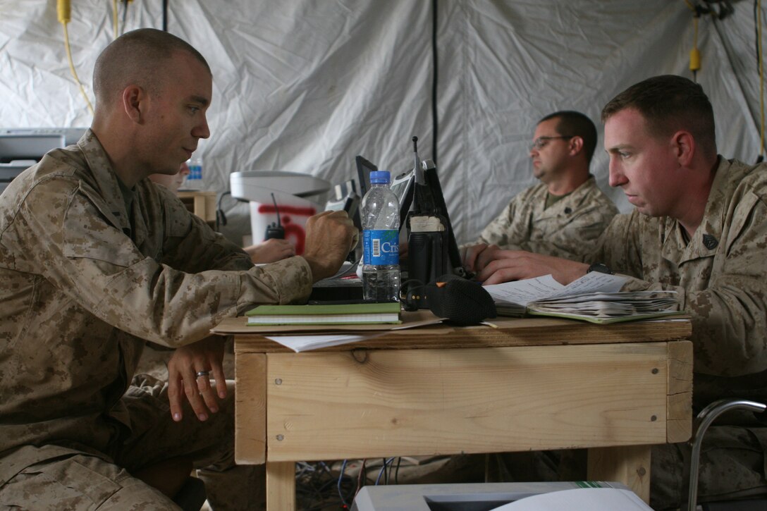 First Lieutenant Nathan L. Nagel (left), the battalion adjutant and Gunnery Sgt. Christopher J. Campbell (right), the administration chief, with Headquarters and Service Company, 1st Battalion, 6th Marine Regiment, work in their office at Forward Operating Base Marjah, April 2. The construction of the base began in early March and serves as a key center of operations within the city of Marjah, Afghanistan.