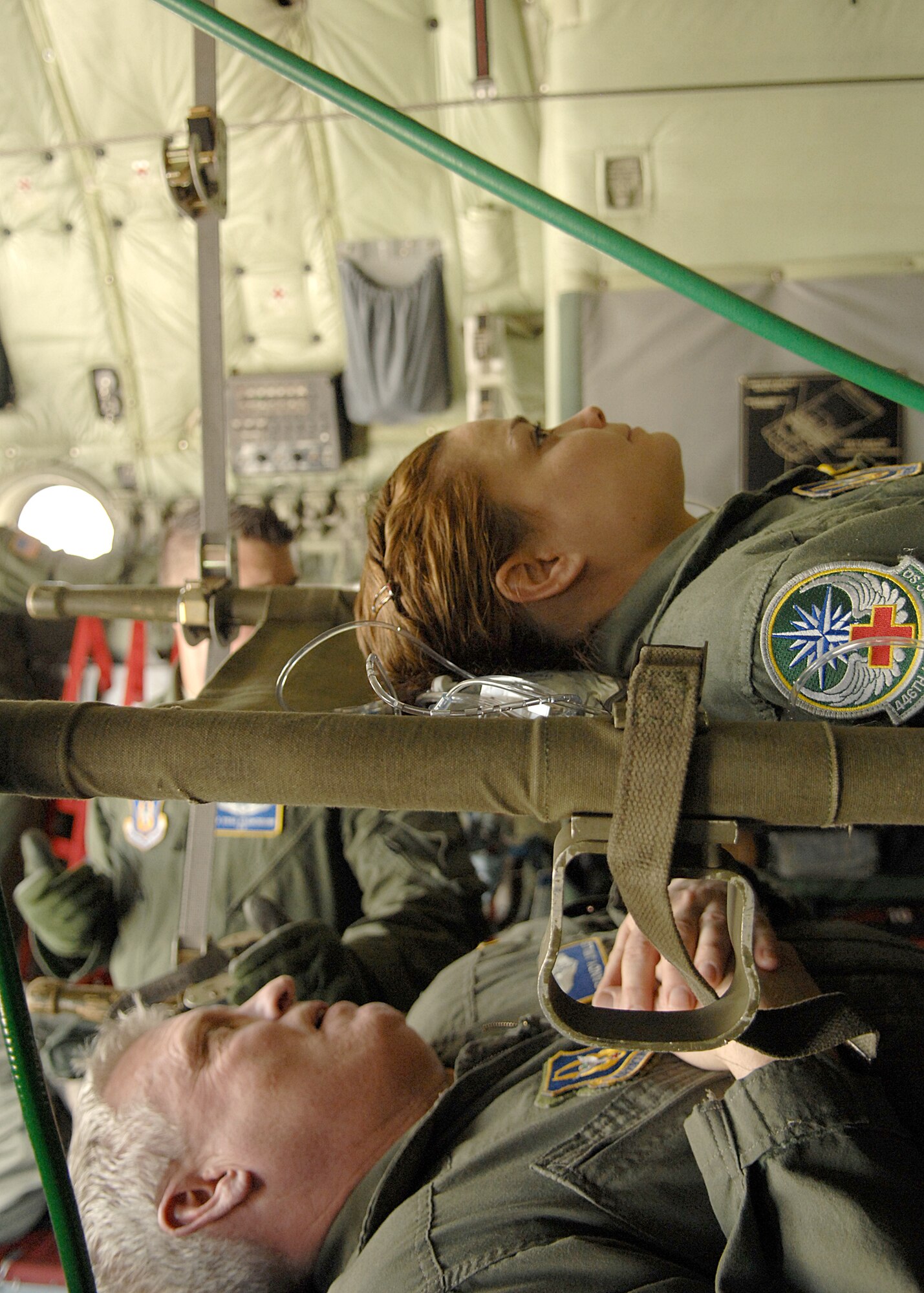 Lt. Col. Randy Miller and Tech. Sgt. Jill Peterson, both from the 446th AES, Joint Base Lewis-McChord, Wash., simulate being patients lying on litters in a C-130 Hercules aircraft. (U.S. Air Force photo by Staff Sgt. Stephen Schester)