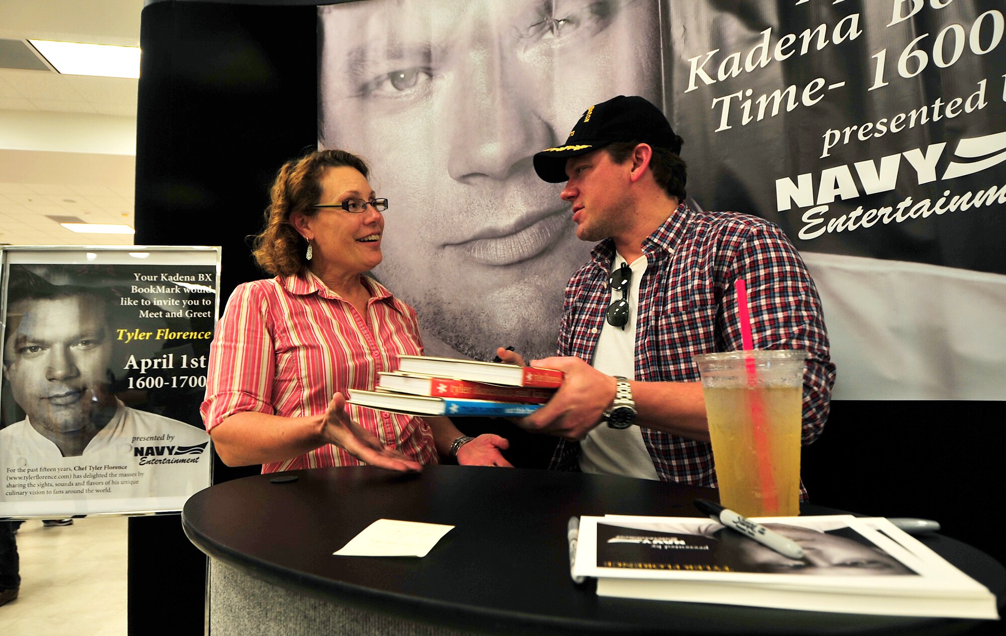 Debbie McCoy receives an autograph from Chef Tyler Florence April 1. A large crowd waited in line as they got their chance for an autograph and photo opportunity with Chef Florence, a television star for several  Food Network shows, at the bookstore located inside the base exchange. Chef Tyler's last stop was Okinawa in part of a Navy entertainment tour of the bases in Japan. That evening he delighted his guests with a six course dinner at the Crow's Nest at Camp Shields, Okinawa, Japan.  (U.S. Air Force photo/Tech. Sgt. Rey Ramon)       