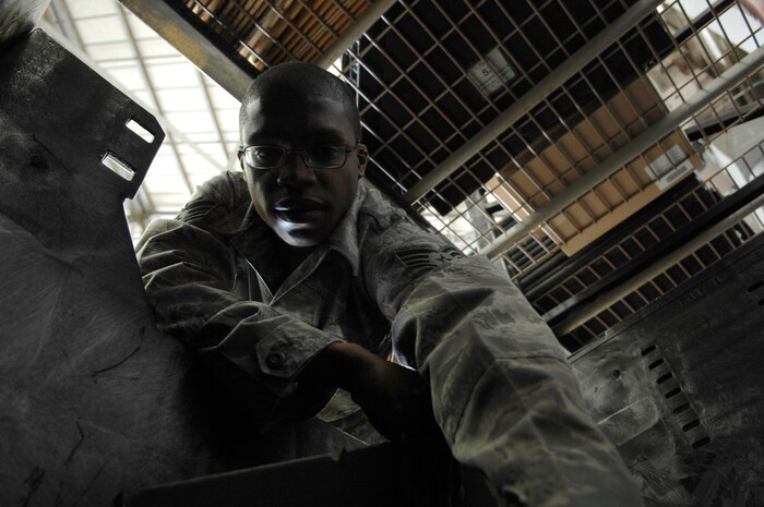 Senior Airman Michael Shaw reaches into an aviation armor storage container at the rail maintenance shop March 26, 2010, on Joint Base Charleston, S.C. The aviation armor is made up of several small, ceramic-covered tiles, which are placed on industrial strength Velcro to form a fixed shape. Airman Shaw is a crew chief with the 437th Aircraft Maintenance Squadron. (U.S. Air Force photo/Senior Airman Timothy Taylor)