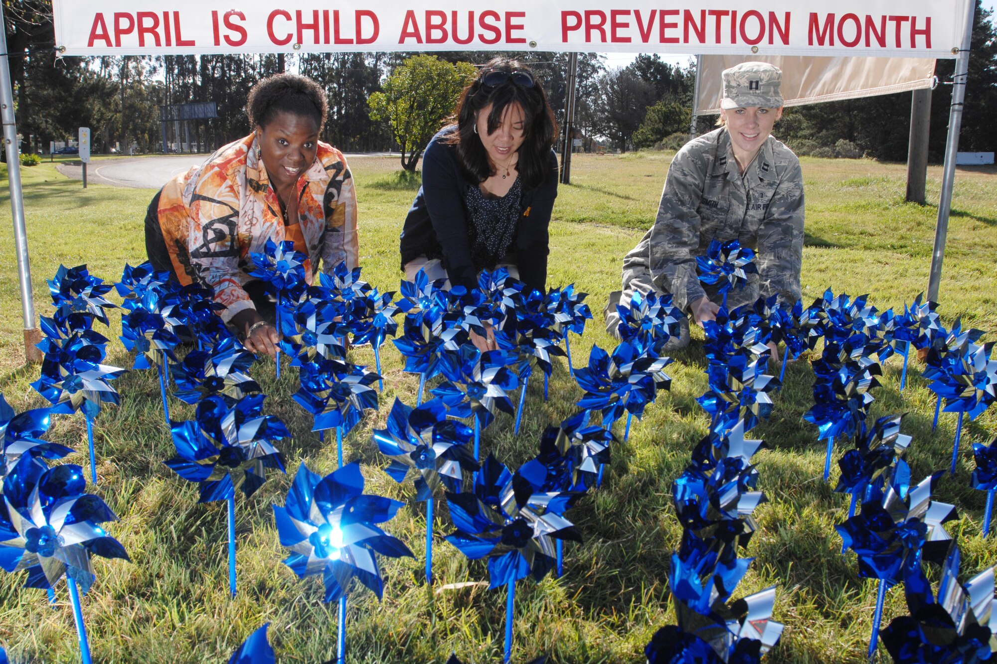 VANDENBERG AIR FORCE BASE, Calif. -- In support of Child Abuse Prevention Month, Ms. Paula Jacobs, Ms. Pauline Chui and Capt. Jodi Smith, all of the 30th Medical Operations Squadron, place pinwheels into the ground for the Pinwheels for Change garden display at the main gate here Thursday, April 1, 2010. The pinwheel represents a happy childhood. (U.S. Air Force photo/Senior Airman Christopher Hubenthal)