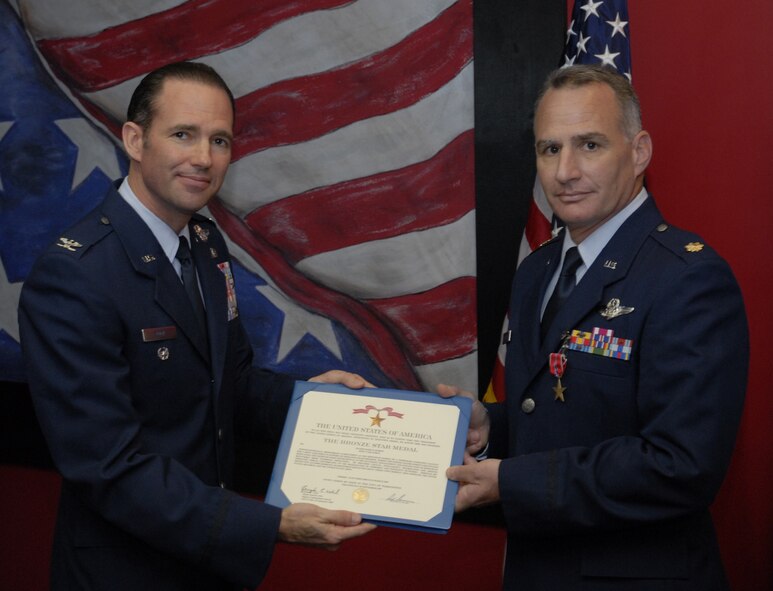 Col. Daniel Zook, 1st Special Operations Wing vice commander, left, presents the citation accompanying the Bronze Star to Maj. Mark Durkin, 1st Special Operations Support Squadron assistant operations officer, at the 1st SOSS at Hurlburt Field Apr. 1. Major Durkin, later promoted to lieutenant colonel during the same ceremony, served as officer-in-charge of a temporary screening facility for a joint task force in support of Operation Iraqi Freedom from Aug. 20, 2008 to March 10, 2009. (U.S. Air Force photo by Airman 1st Class Joe McFadden)