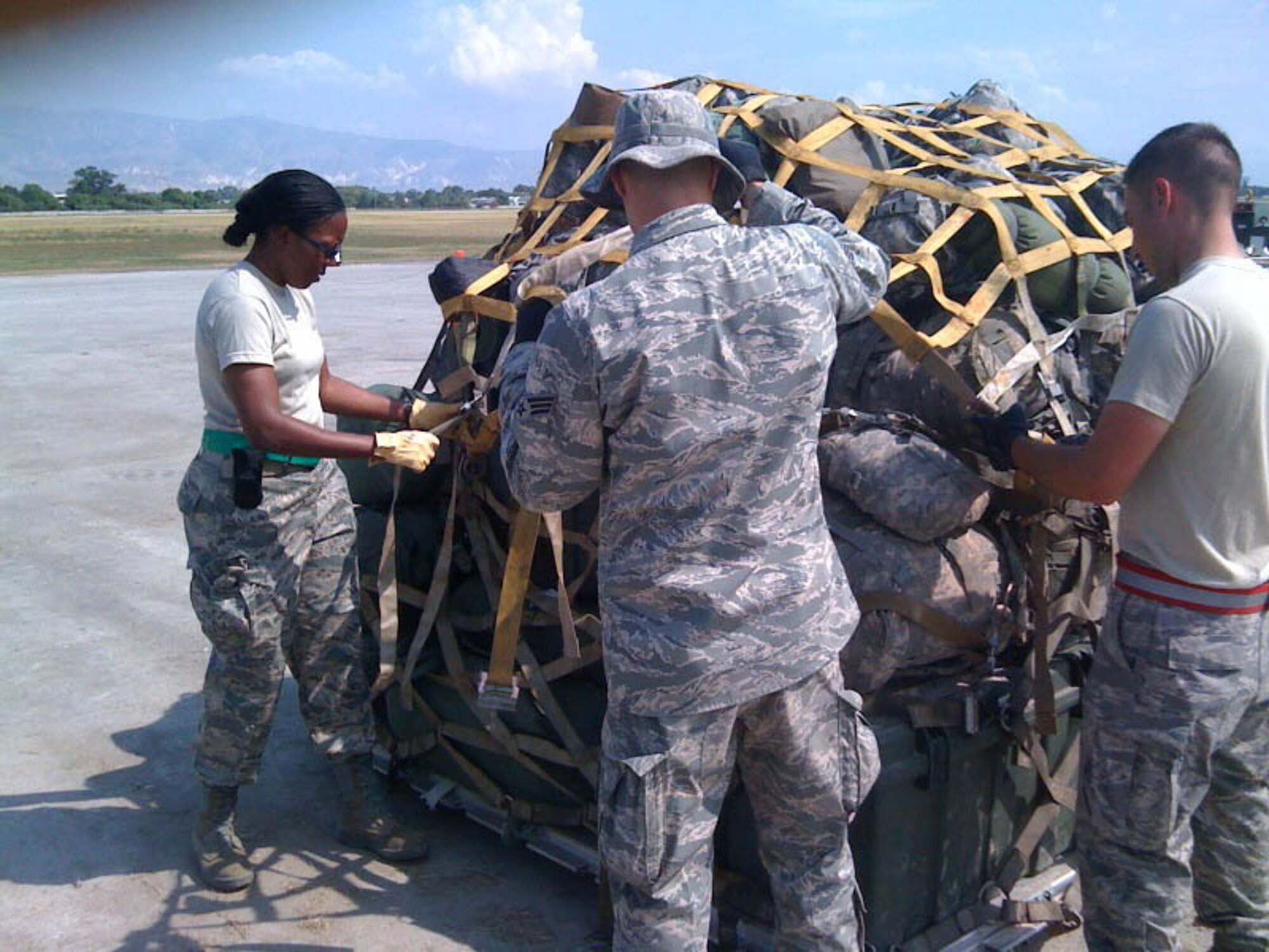 JOINT BASE MCGUIRE-DIX-LAKEHURST, N.J. - Master Sgt. Sebrena Flagg-Briggs an air transportation specialist, helps tie-down cargo as part of her aerial port duties at Port-au-Prince International Airport, Haiti. The reservist is one of several from here who recently deployed to the earthquake-stricken nation in support of Operation Unified Response. (U.S. Air Force photo)