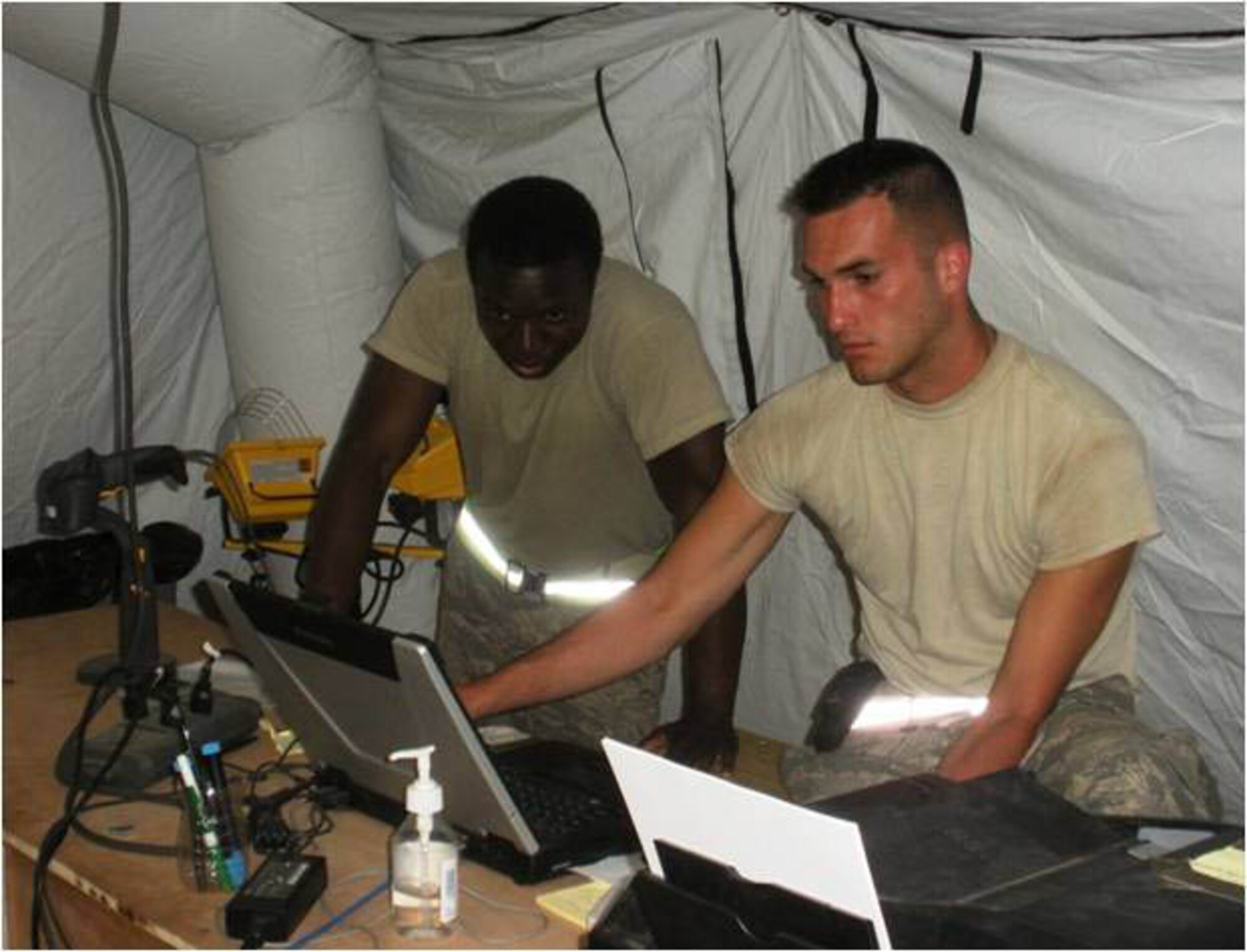 JOINT BASE MCGUIRE-DIX-LAKEHURST, N.J. - Senior Airman Ayotunde Akinkunmi (left) and Staff Sgt. Jared Lacovara, both Reserve aerial port members from here, review aircraft load schedules as part of thier duties in support of Operation Unified Response in Port Au Prince, Haiti. Nine Airman from the 35th and 88th Aerial Port Squadrons deployed mid-February to help vicitms the earthquake-stricken county and assist with the humanitarian aid mission. (U.S. Air Force photo)