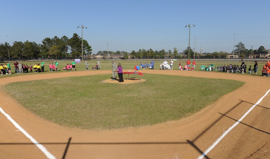 MOODY AIR FORCE BASE, Ga. -- All youth league teams gather around the infield as Nikki Bennett, 23rd Force Support Squadron youth program director, gives Col. Gary Henderson, 23rd Wing commander, certificates  to present to each team sponsor here March 30. All of Moody’s spring sports teams came to watch the wing commander throw the first pitch to kick off the beginning of their season. (U.S. Air Force photo by Airman 1st Class Benjamin Wiseman/RELEASED)