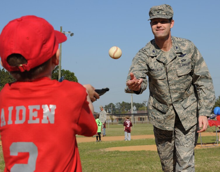 MOODY AIR FORCE BASE, Ga. -- Col. Gary Henderson, 23rd Wing commander, throws the ceremonial first pitch to Aiden Bowen, son of Lori and Tech. Sgt. Christopher Bowen, 23rd Equipment Maintenance Squadron, to officially start youth spring sports here March 30. All youth spring sports teams, including soccer and tee ball, celebrated the beginning of the season. (U.S. Air Force photo by Airman 1st Class Benjamin Wiseman/RELEASED)