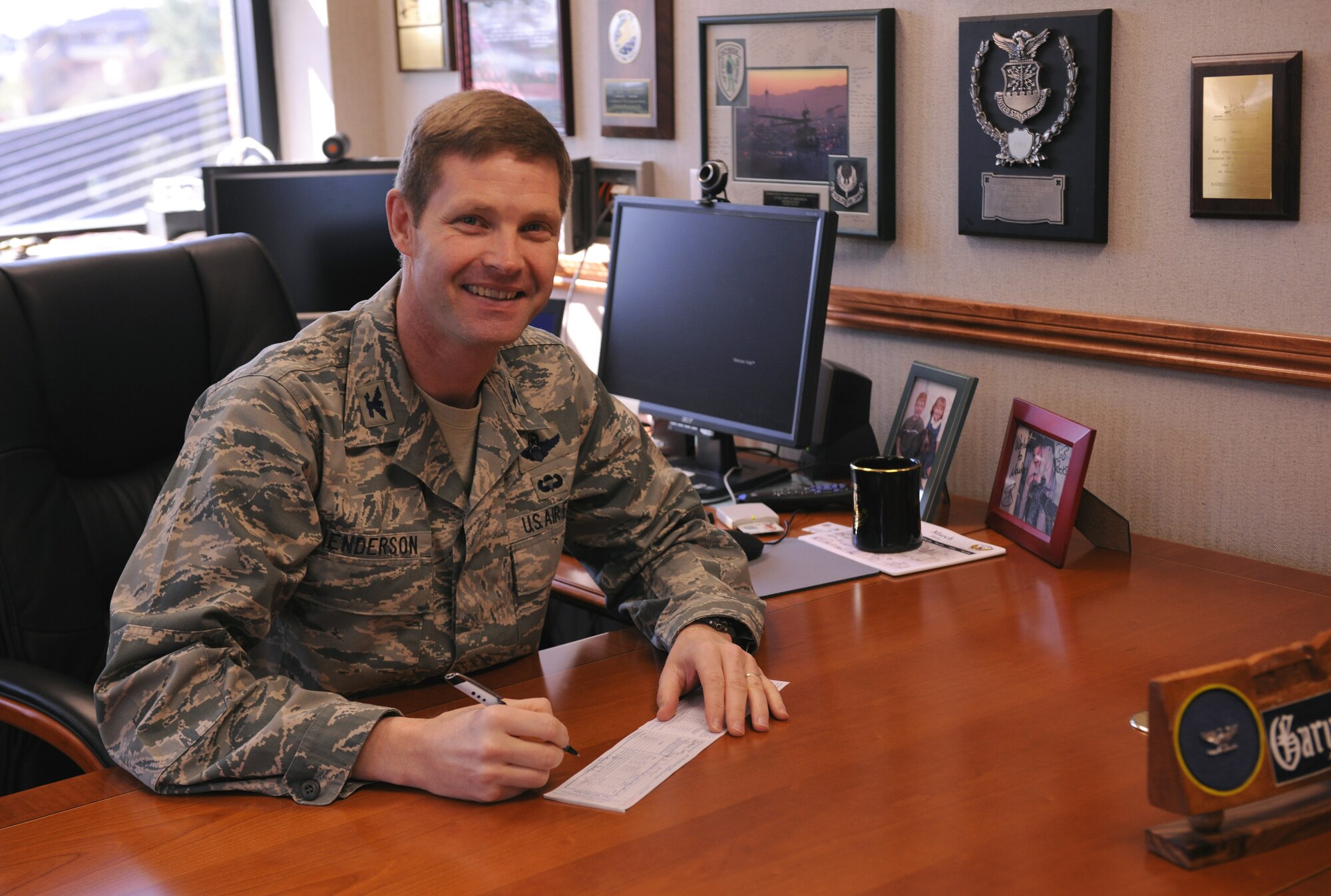 MOODY AIR FORCE BASE, Ga. -- Col. Gary Henderson, 23rd Wing commander, signs a form to pledge money to the Air Force Assistance Fund here March 30. The AFAF was established to provide monetary support to charities that support Air Force families including active duty, retirees, reservists, guard members and their dependents and surviving spouses. (U.S. Air Force photo by Airman 1st Class Benjamin Wiseman/RELEASED)