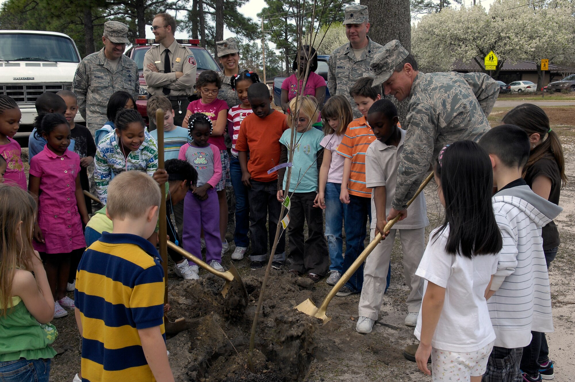 Col. Charles Dunn, 43rd Mission Support Group Commander, helps children from the Pope School Age Program plant a tree in celebration of Arbor Day in front of the Shool Age Program building March 26. Arbor Day is a nationally-celebrated observance that encourages tree planting and care. (U.S. Air Force photo/Senior Airman Kris Levasseur)