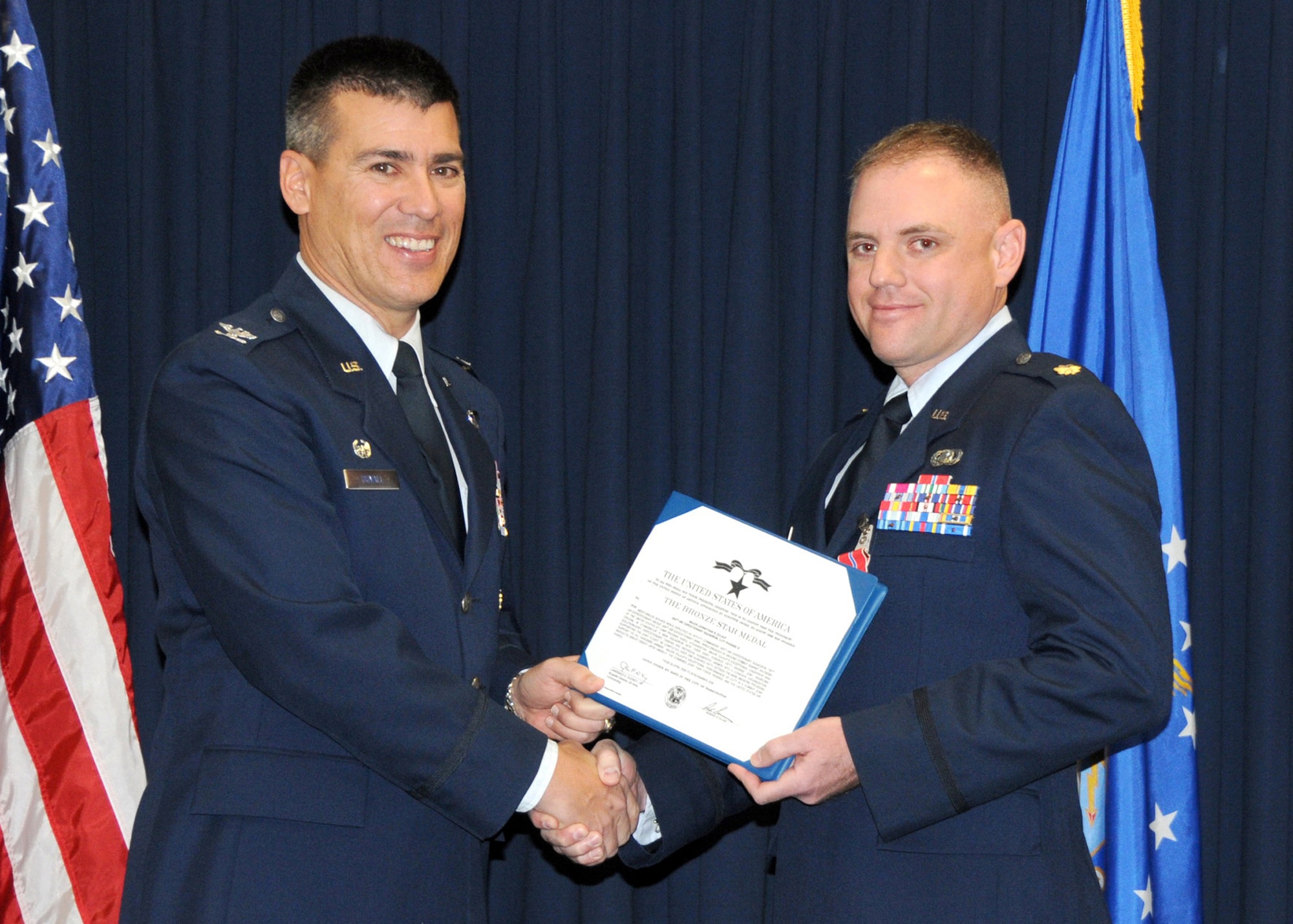 Col. Michael S. Duvall, 377th Air Base Wing commander, left, presents the Bronze Star Medal to Maj. Johnathan B. Zulauf, 377th ABW Command Post, at a ceremony March 5. Major Zulauf distinguished himself in a combat zone through exceptionally meritorious service while serving as deputy commander of the 855th Air Expeditionary Squadron, while engaged in ground combat operations against the enemies of the United States, supporting Operation Enduring Freedom at Camp Phoenix, Afghanistan, from April 29 through Nov. 20, 2009. Major Zulauf personally planned and executed more than 150 mounted combat patrols in the critical suicide-vehicle-borne improvised explosive device-rich Kabul Capital Region, with more than 3,200 miles on Afghanistan roads, placing him at significant risk to hostile action multiple times throughout his tour.U.S. Air Force Photo by Dennis Carlson
