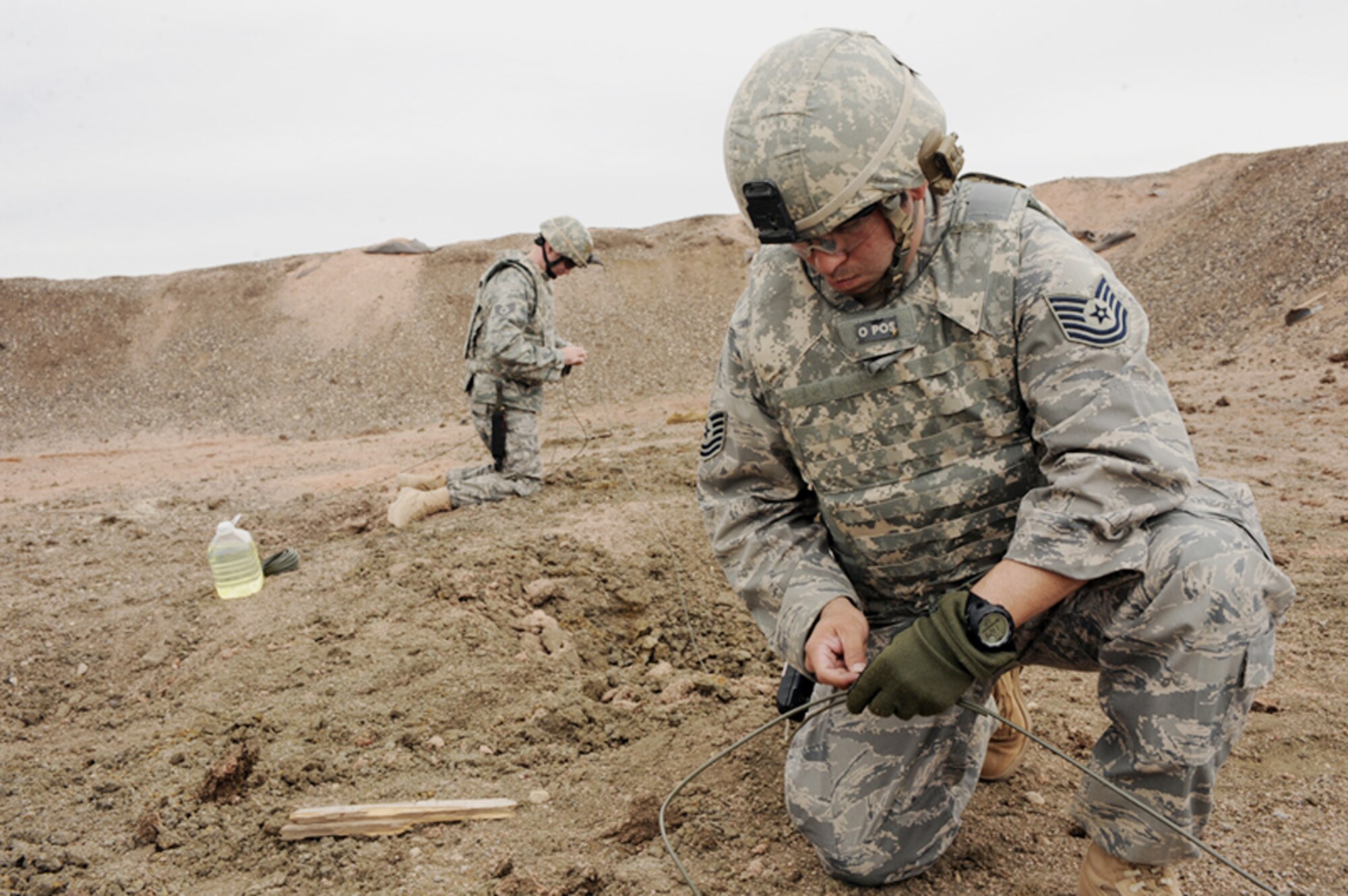 Tech. Sgt. Jayson Wells, 28th Civil Engineer Squadron explosive ordnance disposal journeyman, sets the main line for a shaped charge explosion March 30, 2010, at Ellsworth Air Force Base, S.D. (U.S. Air Force photo/Senior Airman Adam Grant)   