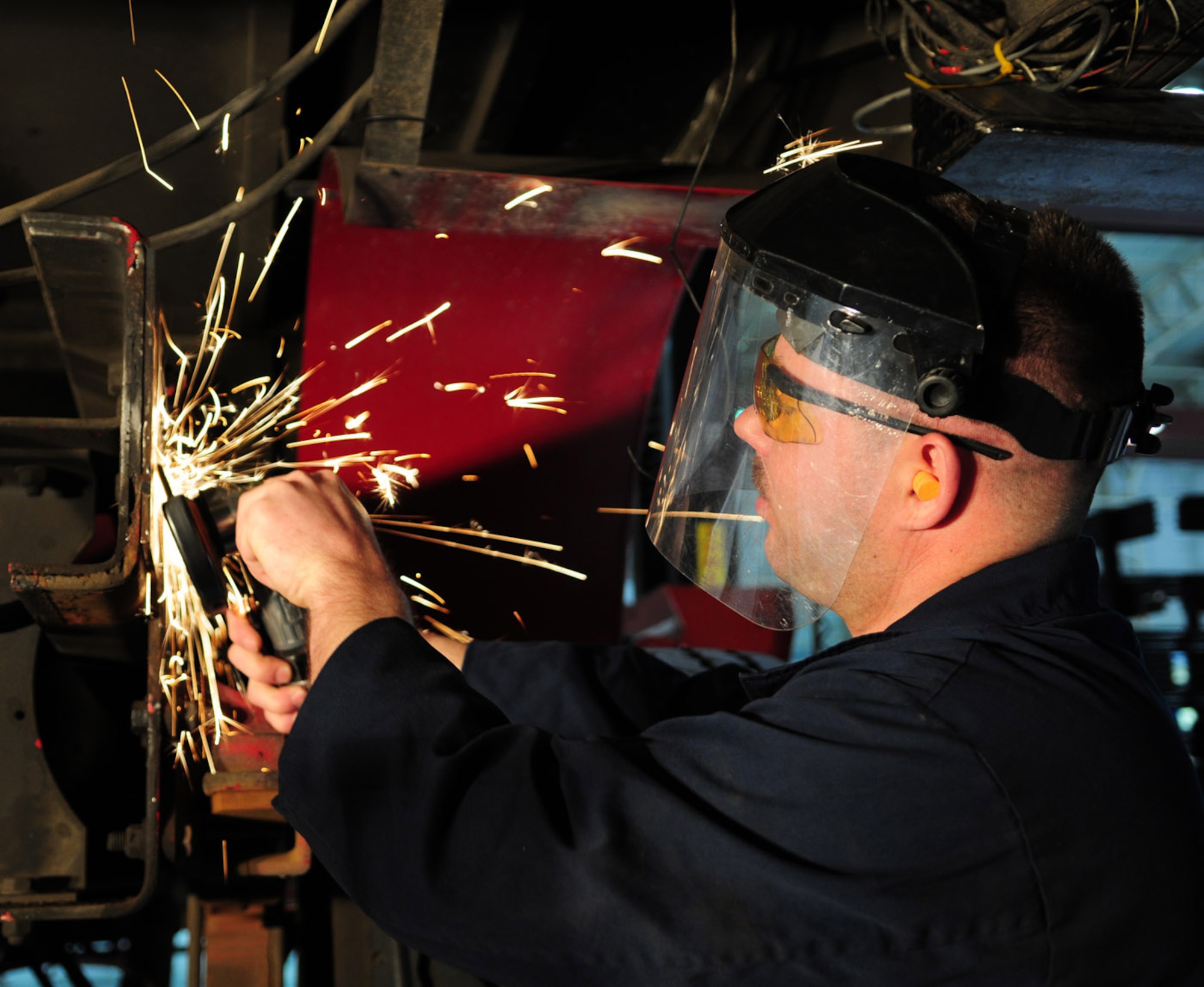 Staff Sgt. Shaun Walker, a reservist from the 459th Logistics Readiness Flight at Andrews Air Force Base, Washington D.C., uses a grinder to clean up frame rails in preparation for new on a rescue truck belonging to the 100th Civil Engineer Squadron Fire Department. Sergeant Walker was one of 23 Airmen completing annual training here March 13 through 28. (U.S. Air Force photo/Karen Abeyasekere)