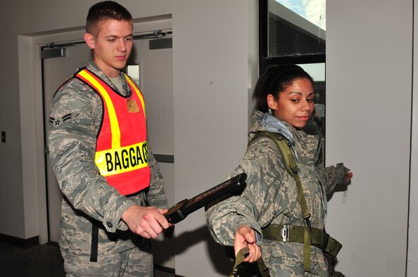 SEYMOUR JOHNSON AIR FORCE BASE, N.C. -- Airman 1st Class Brandon Holliday, 4th Component Maintenance Squadron avionics sensor technician, uses a hand-held metal detector to scan Senior Airman Brittany Cline, 4th Equipment Maintenance Squadron non-destructive inspector, during a Phase I operational readiness exercise here March 29, 2010. The detector checks for any metal objects a person may be hiding underneath their clothing. Holliday is from Little Rock, Ark., and Cline hails from Toone, Tenn. (U.S. Air Force photo/Senior Airman Rae Perry)
