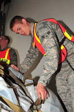 SEYMOUR JOHNSON AIR FORCE BASE, N.C. -- Airman 1st Class Brandon Holliday, 4th Component Maintenance Squadron avionics sensor technician, tightens a cargo strap on a pallet during a Phase I operational readiness exercise here March 29, 2010. A Phase one exercise evaluates a unit's preparations and mobilization from peacetime readiness into wartime posture on short notice. Holliday hails from Little Rock, Ark. (U.S. Air Force photo/Senior Airman Rae Perry)