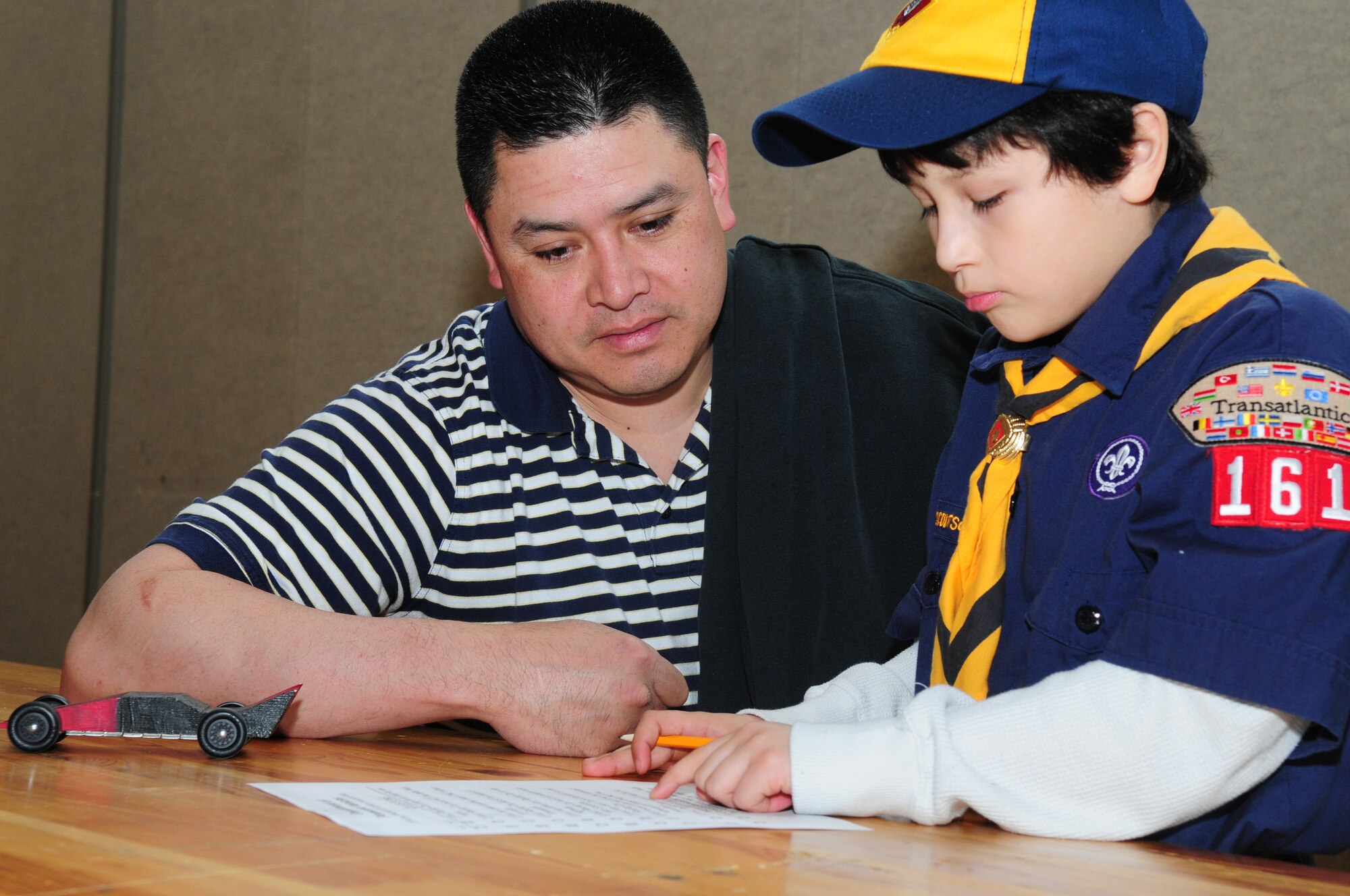 BITBURG ANNEX, Germany -- Tech. Sgt. Galen Leon, 52nd Logistics Readiness Squadron assists his son, Matthew Leon, with a licensing test March 27.  A license is issued upon test completion allowing the drivers entry into the annual Pinewood Derby. (U.S. Air Force photo/Staff Sgt. Heather M. Norris)