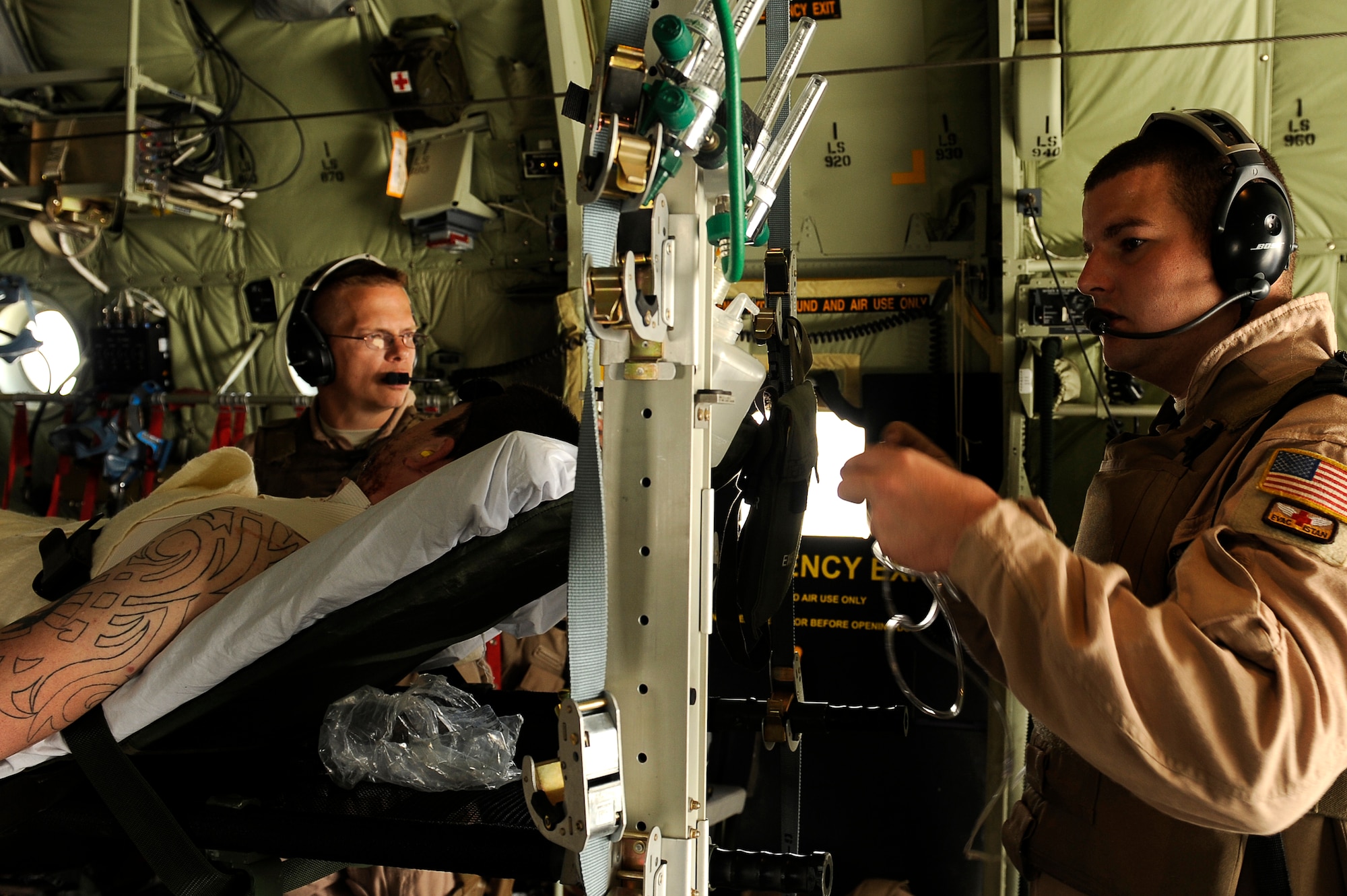 U.S. Air Force Maj. Richard Foote (left) and Tech. Sgt. Chris Hines, 455th Expeditionary Aeromedical Evacuation Flight, set up an oxygen system for a wounded U.S. servicemember in a C-130 over Afghanistan, March 26, 2010. The 774th Expeditionary Airlift Squadron in Bagram flies C-130 aeromedical evacuations across Afghanistan. Major Foote is deployed from Maxell Air Force Base, Ala., and is from Mobile, Ala. Sergeant Hines is deployed from Maxwell AFB, Ala., and is from McClellan, Fla. (U.S. Air Force photo by/ Tech. Sgt. Jeromy K. Cross/released)