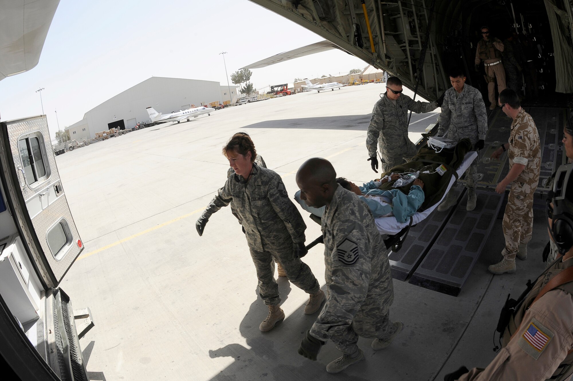 NATO forces move a wounded Afghan National Army soldier to an ambulance at Kandahar Airfield, Afghanistan, March 26, 2010. The 774th Expeditionary Airlift Squadron in Bagram flies C-130 aeromedical evacuations across Afghanistan. (U.S. Air Force photo by/ Tech. Sgt. Jeromy K. Cross/released)




