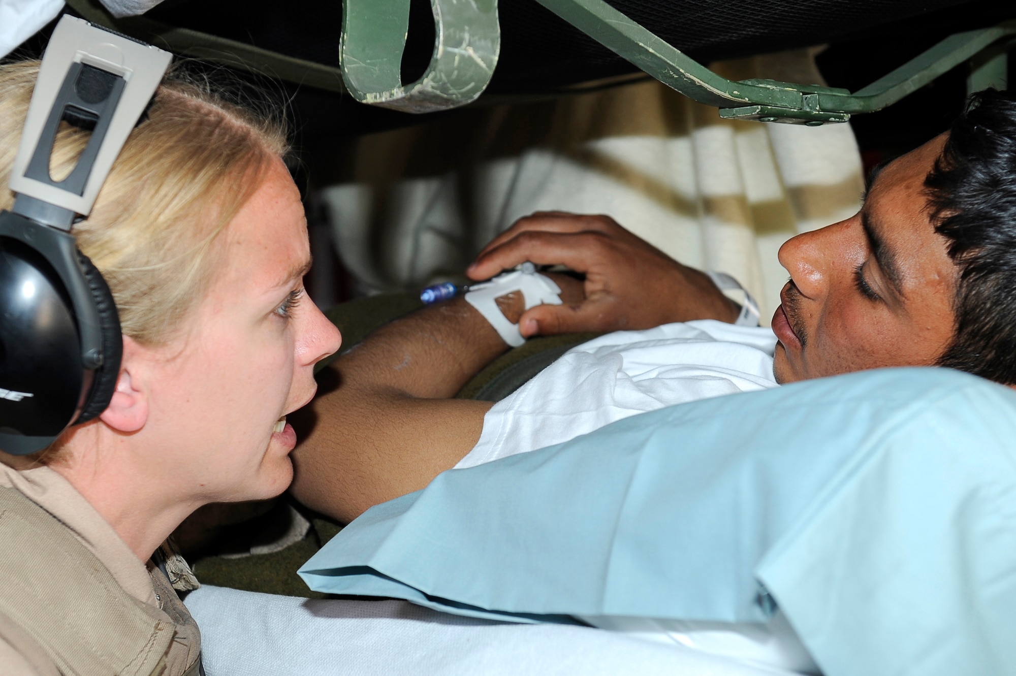 U.S. Air Force Tech. Sgt. Kim Price, 455th Expeditionary Aeromedical Evacuation  Flight, checks on the condition of a wounded Afghan National Army soldier during a medical evacuation at Camp Bastion, Afghanistan, March 26, 2010. The 774th Expeditionary Airlift Squadron in Bagram flies C-130 aeromedical evacuations across Afghanistan. Sergeant Price is deployed from Maxwell Air Force Base, Ala., and is from Pittsburgh, Pa. (U.S. Air Force photo by/ Tech. Sgt. Jeromy K. Cross/released)