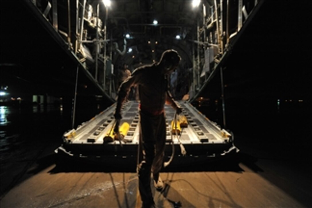 U.S. Air Force Senior Master Sgt. Archie Brawton prepares to place chalks under a C-130 Hercules aircraft after its arrival at Baghdad International Airport in Iraq on March 26, 2010.  Brawton is a loadmaster deployed from the 758th Airlift Squadron out of Pittsburgh Air Reserve Station, Pa.  