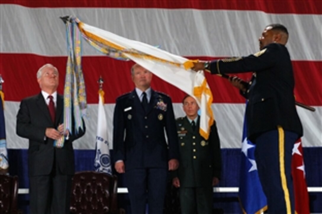 Defense Secretary Robert M. Gates attaches the Joint Meritorious Unit Award to the U.S. Transporation Command guidon while U.S. Air Force General Duncan McNabb, commander Transcom's commander, watches, during a ceremony on Scott Air Force Base, Ill., April 1, 2010.