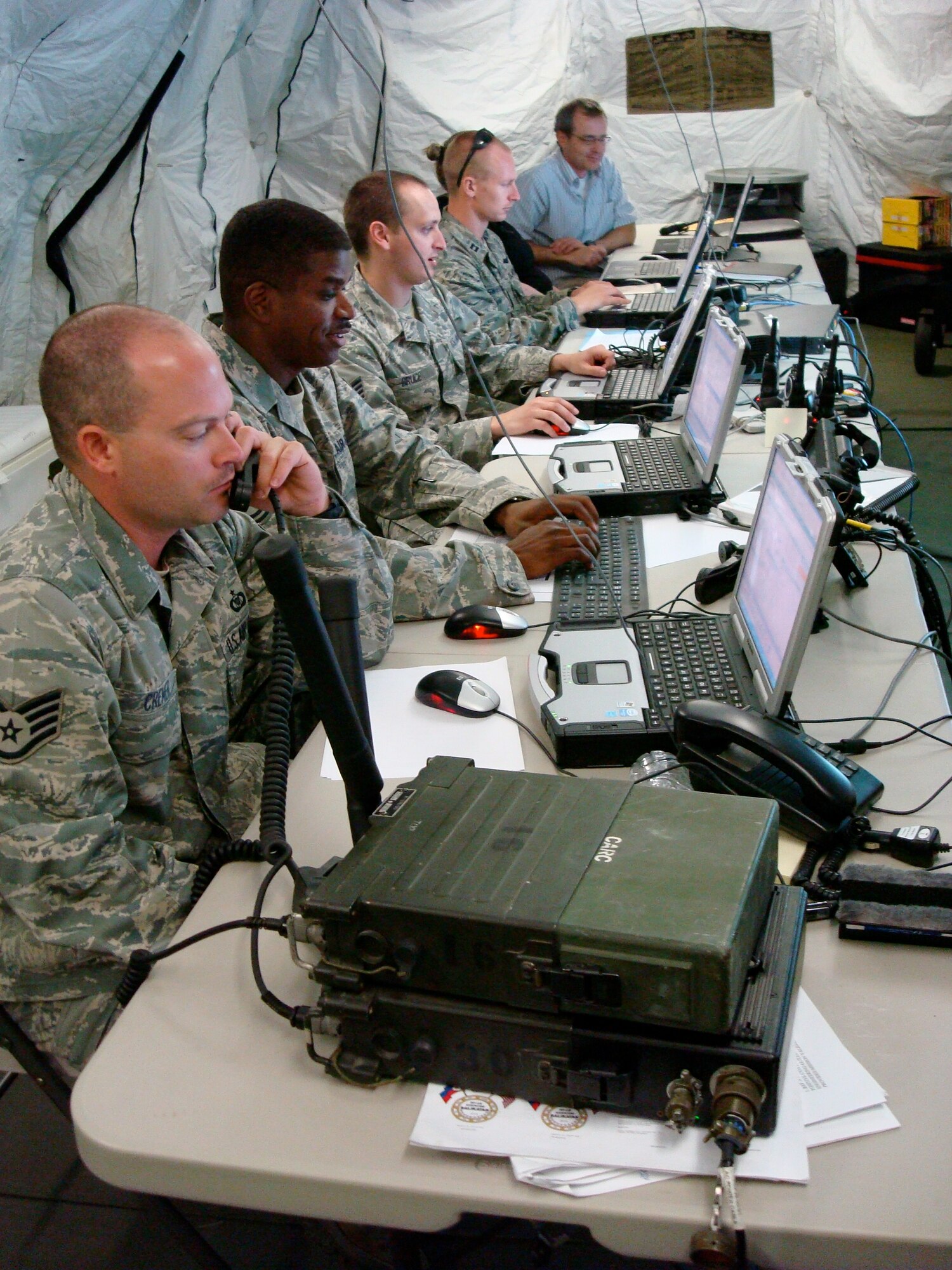 (Left to right) Staff Sgt. Justin Cremer, Tech. Sgt. Christopher Currie, Staff Sgt. Jason Bruce, and Capt. Timothy Swierzbin, from the 25th Air Support Operations Squadron, work together using a common operational picture along with Mr. Jeff Oakerson of CACI International Inc., to de-conflict aircraft participating in exercise Balikatan. Balikatan is an annual bilateral exercise designed to increase interoperability between the U.S. and Philippine air forces, and exercises the two nation's ability to operate together when responding to natural disasters. (U.S. Air Force courtesy photo)