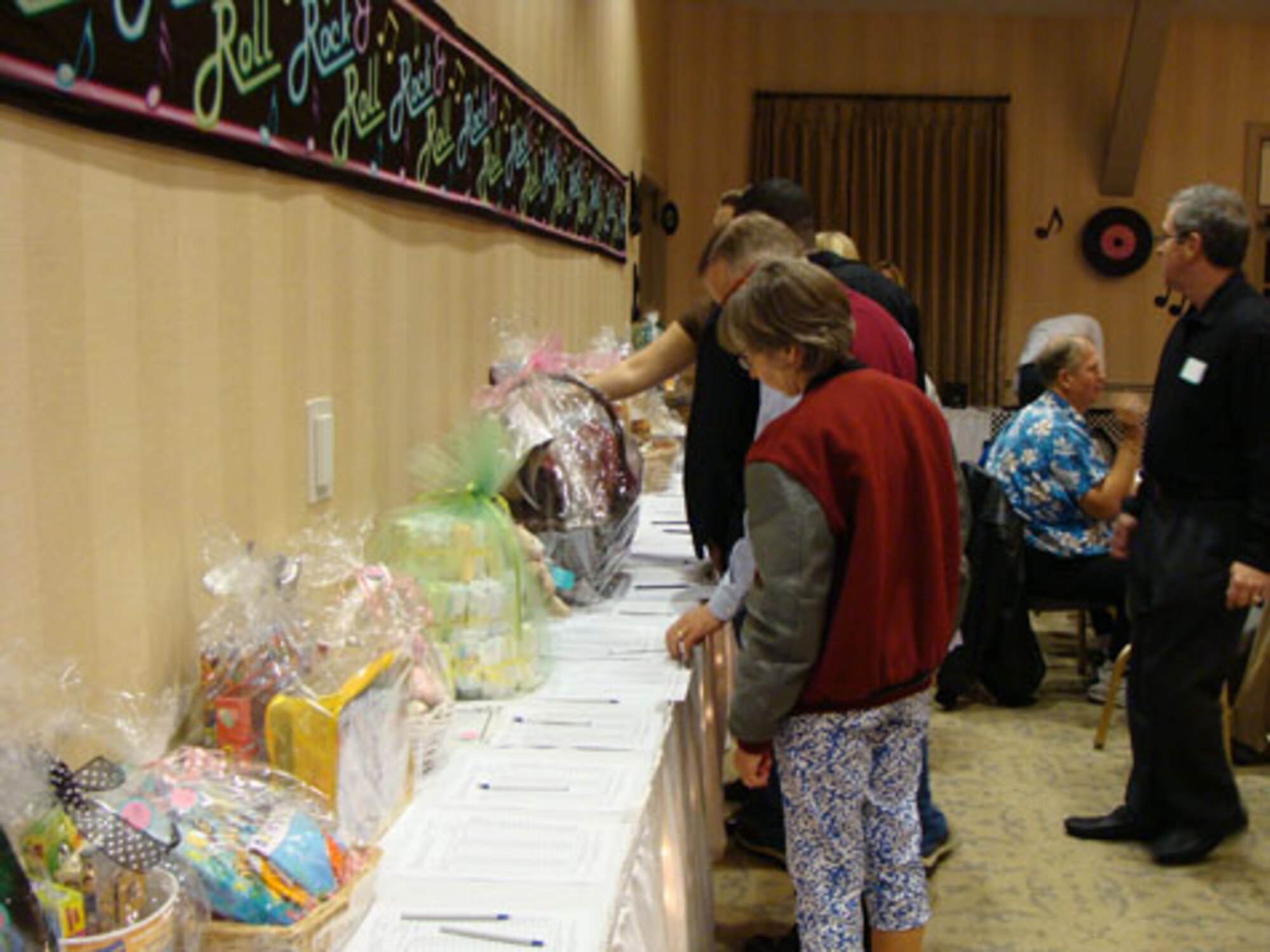 Event goers check out the silent auction items at the Los Angeles Air Force Base Spouses Club Auction for Education at the Fort MacArthur Community Center, March 13.  This year’s event had a 1950’s theme and included a silent auction, dessert auction and sock hop.  The auction raised $17,000. Proceeds from the event benefit college scholarships for family members who are graduating from high school this year. The scholarships are scheduled to be awarded at a ceremony, May 13.  (Photo courtesy of the LAAFB Spouses Club)