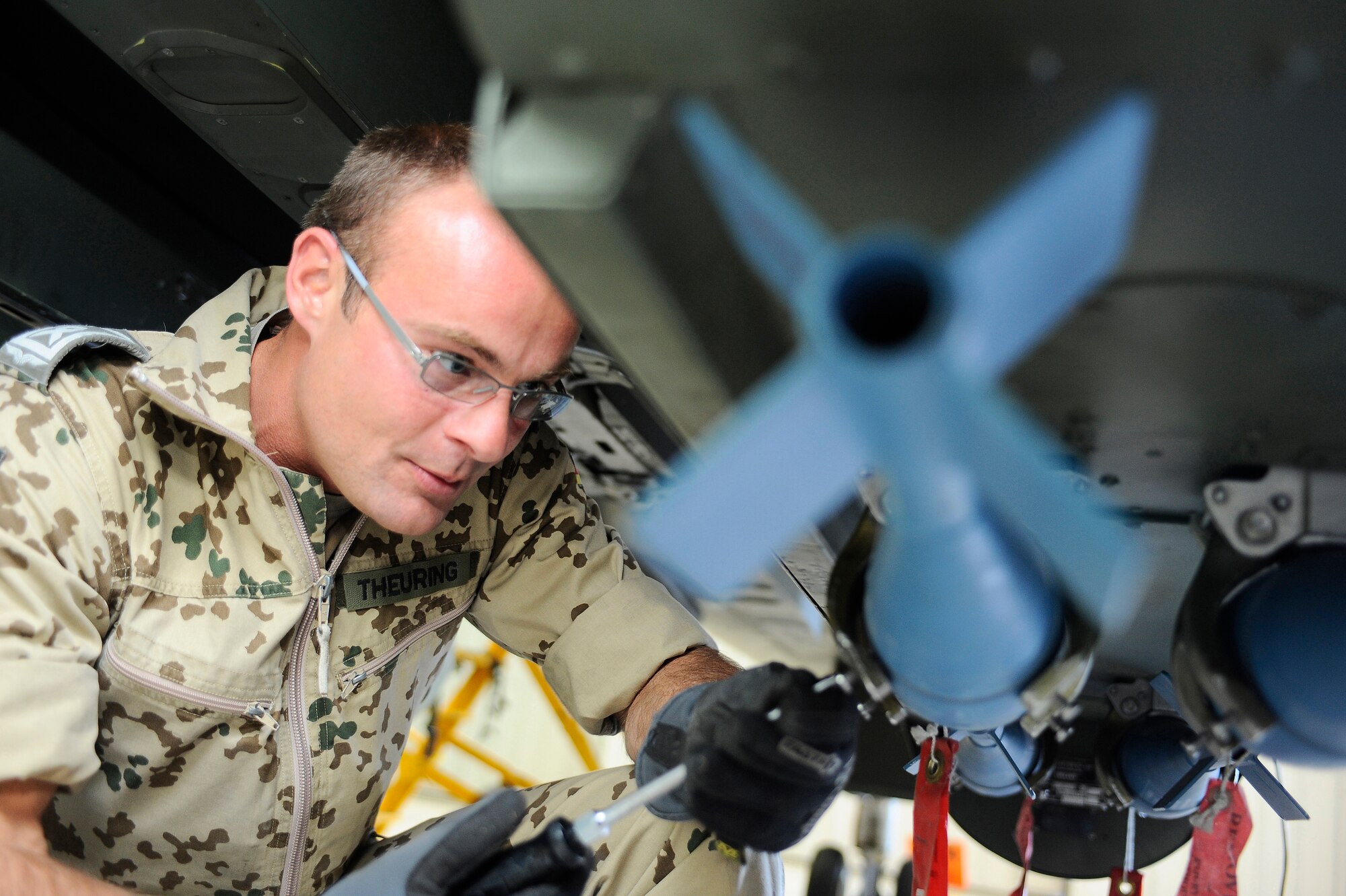 HOLLOMAN AIR FORCE BASE, N.M. -- Master Sgt. Michael Theuring, First Line Maintainer for the German Air Force Flying Training Center, installs a training bomb on a Tornado, March 29, 2010. First Line Maintainers perform Preflight inspections before installing bombs, rockets, missiles, laser ports and gun munitions onto German Tornados. Through-flight and Post-flight inspections are also conducted every time the Tornado returns from a sortie. (U.S. Air Force photo by Airman 1st Class Veronica Stamps) (Released)
