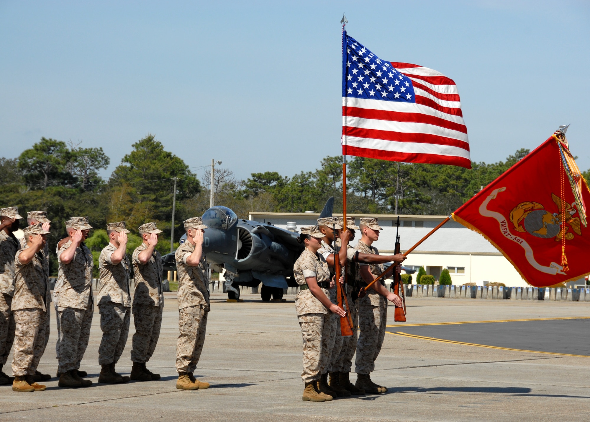 Squadron staff members (left) salute during the playing of the National Anthem as part of the Marine Fighter Attack Training Squadron 501 stand-up ceremony April 2 at Eglin Air Force Base, Fla. The 501st becomes the first Marine JSF squadron and also the first Marine squadron embedded into a Air Force Wing. Maj. Gen. James F. Flock, 2nd Marine Aircraft Wing commander, called the occasion "the next chapter in the future of Marine aviation." The band came from Cherry Point, N.C. to perform at the ceremony. (U.S. Air Force photo/Samuel King Jr.)