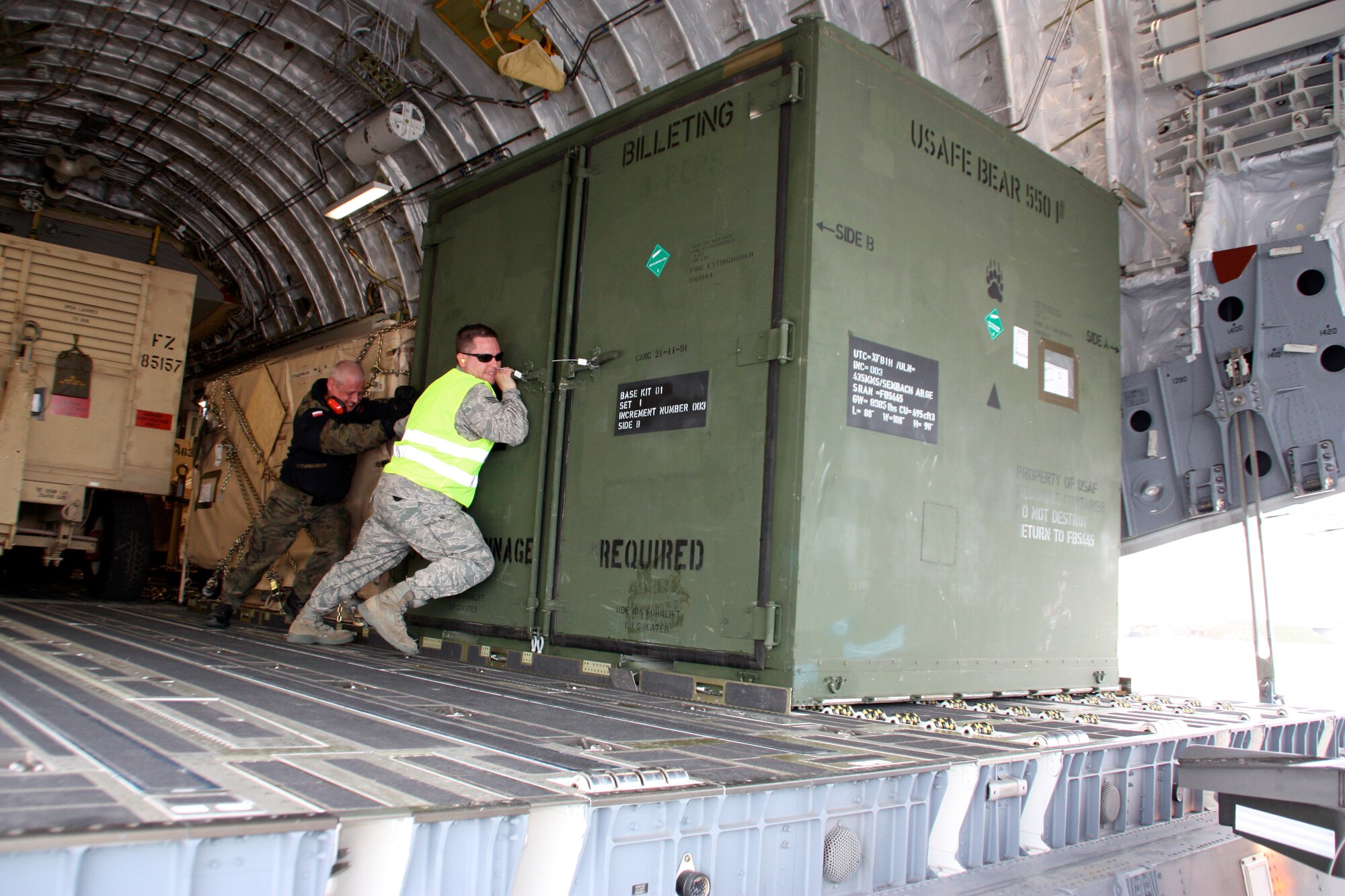 Airmen from the multinational Heavy Airlift Wing move a billeting kit March 30, 2010, in preparation for shipment to units in Afghanistan. HAW Airmen have moved more than 2.1 million pounds of war reserve material essential to surge operations supporting the International Security Assistance Force in Afghanistan. The HAW, based at Papa Air Base, Hungary, operates three C-17 Globemaster III aircraft independently of NATO's military command and comprises 12 nations that activated the unit July 27, 2009. (HAW photo/Finnish Capt. Juha Miettinen)