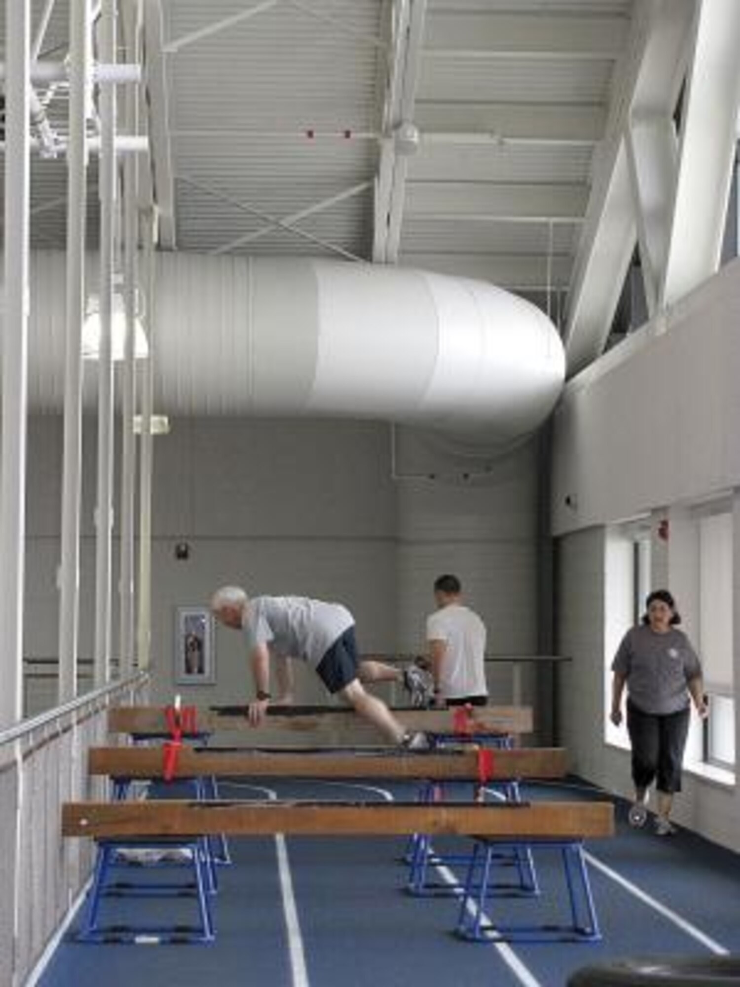 Paul Hulet, 505th Combat Sustainment Squadron country program manager, jumps over hurdles in the plyometric portion of the obstacle course laid out along the indoor track at the Warrior Health and Fitness Center on March 25. (Air Force photo by Lee Anne Hensley)