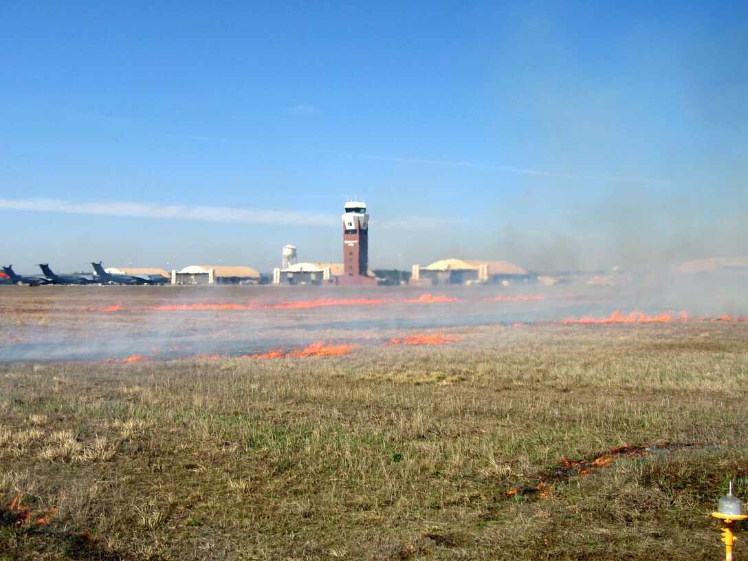 Westover fire crews work Friday with a team from the U.S. Forest Service to use prescribed fires to burn about 300 acres of grasslands at Westover Air Reserve Base, Mass.  The controlled burn reduces the chance for wild brushfires, discourages invasive weed growth, encourages native grass growth and eliminates habitats for raptor prey, like mice.  It also creates a more suitable habitat for two state-listed rare bird species: the upland sandpiper and grasshopper sparrow.  Prescribed fire is a recognized natural resource management tool.  (U.S. Air Force Photo/ Jack Moriarty)