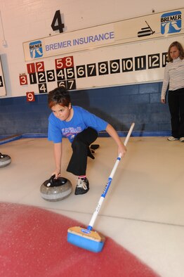 MINOT, N.D. -- Allie Arellano, daughter of Laurie Arellano, 5th Bomb Wing chief of public affairs, tries out throwing the stone during a curling lesson March 26 at the Minot Curling Club. The Minot Curling Club is open November through March and provides lessons and competition opportunities for Minot Airmen and family members of all skill levels. (U.S. Air Force photo by Staff Sgt. Stacy Moless) 
