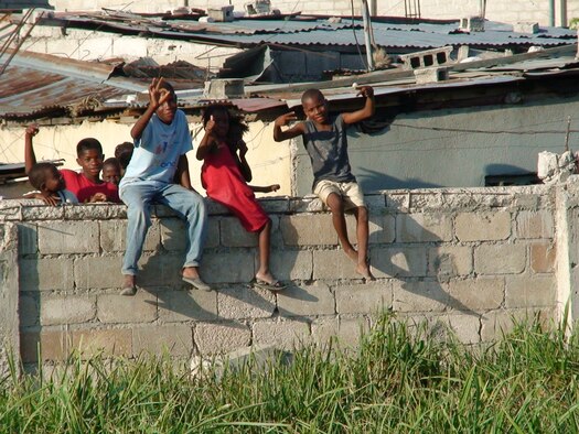 PORT-AU-PRINCE, Haiti -- Local children sit on a perimeter wall near the Toussaint L'Ouverture International Airport here, in March. The airport, located in Port-au-Prince, Haiti, is being protected by approximately 30 remaining members from the 823rd Expeditionary Security Forces Squadron, deployed from Moody Air Force Base, Ga.(Contributed U.S. Air Force photo/RELEASED)
