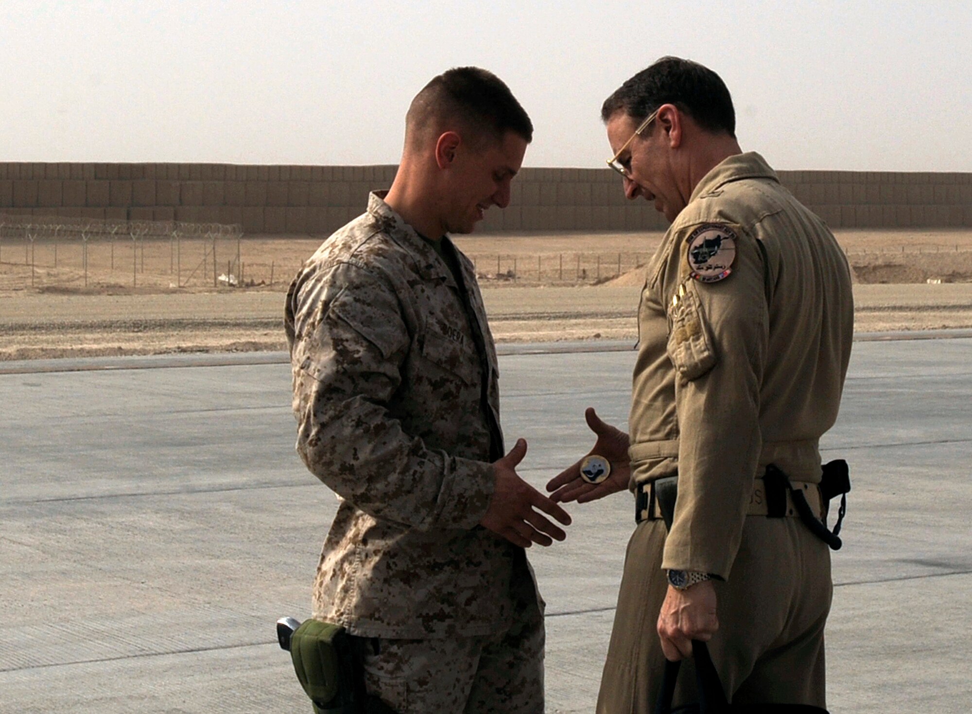 Marine 1st Lt. Benjamin Boera, left, 5th Battalion 11th Marines High Mobility Artillery Rocket System Tango Battery platoon commander, receives a commander?s coin from his dad, Brig. Gen. Michael Boera, 438th Air Expeditionary Wing and Combined Air Power Transition Force commander, March 28, 2010, at Camp Bastion, Afghanistan. After an hour-long lunch the duo returned to the flight-line walking slowly to the waiting C-27 to savor their time together. (U.S. Air Force photo/Staff Sgt. Manuel J. Martinez/released)