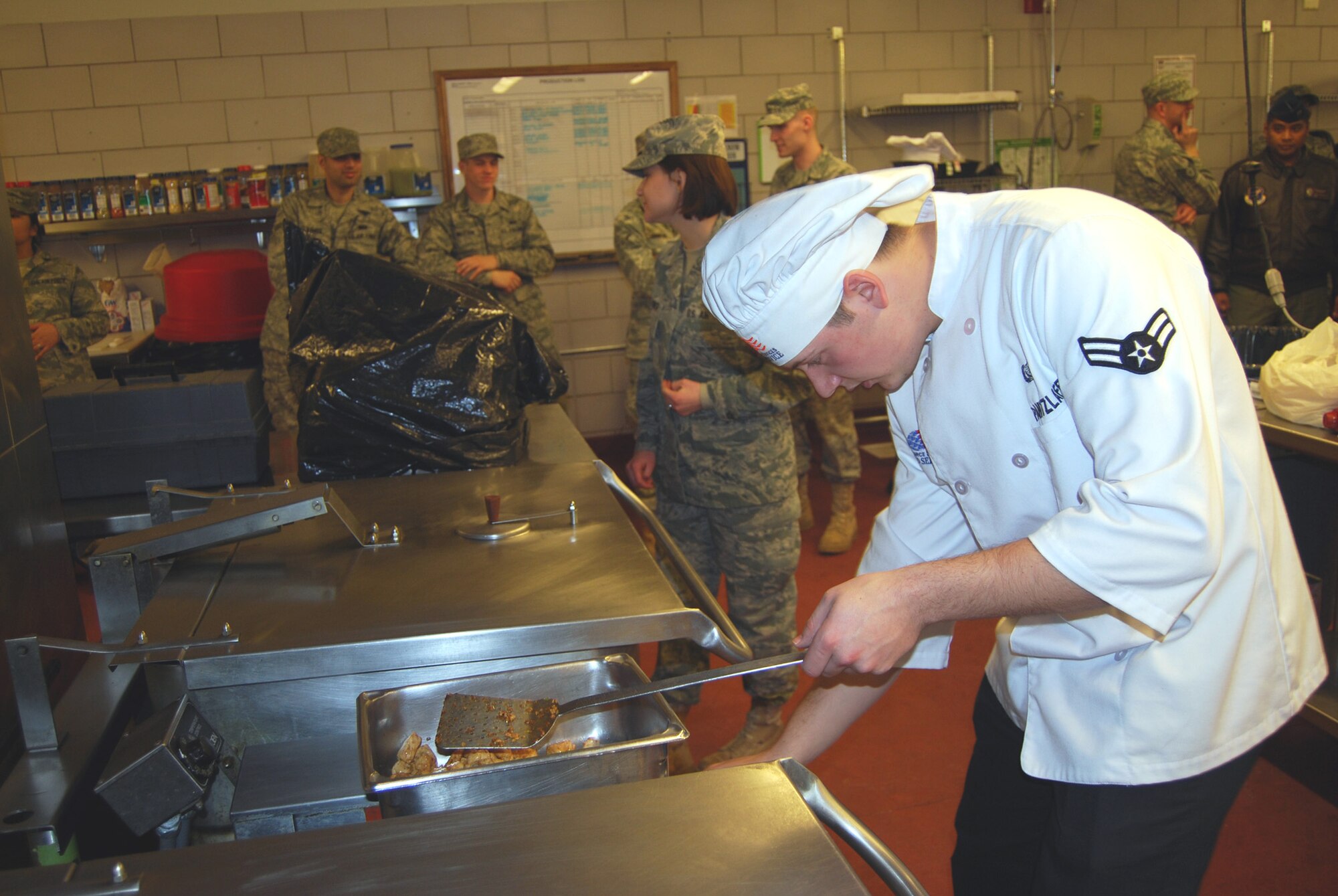 Airman 1st Class Tyler Pantzlaff, 10th Missile Squadron chef, adjusts the temperature on the stove during Warrior Chef competition at the Elkhorn Dining Facility March 30.(U.S Air Force photo/Airman 1st Class Kristina Overton)