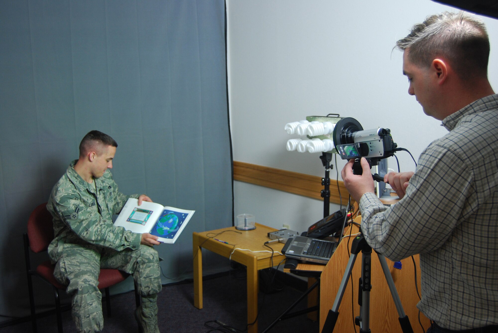 Tech Sgt. Joseph Hansen, 341st Force Support Squadron readiness non-commissioned officer records Airman 1st Class Brandon Luba, 16th Munitions Squadron maintenance personnel, reading a story for the new Reading for Readiness program at the base library March 26. (U.S Air Force photo by/Airman 1st Class Kristina Overton)