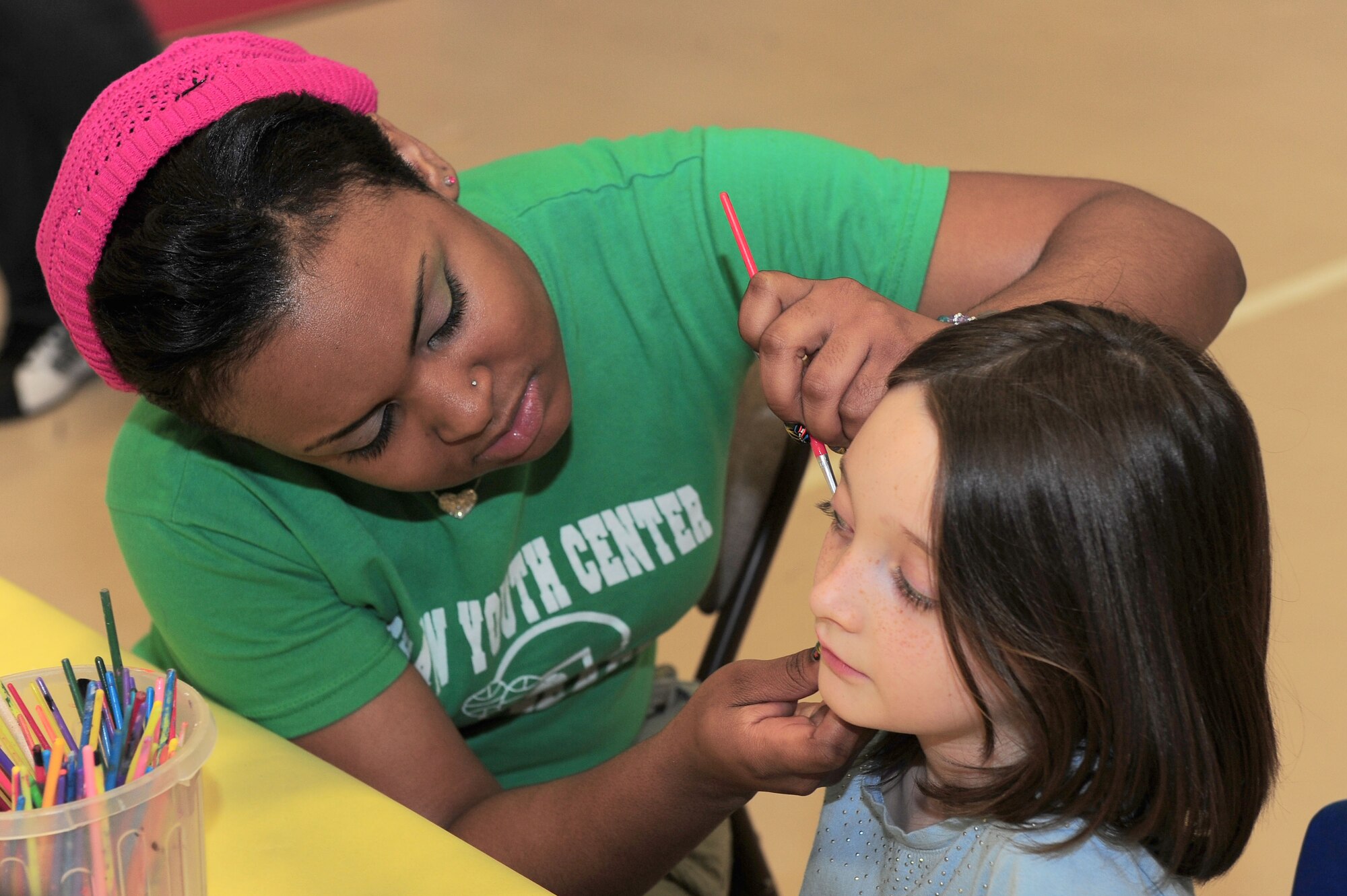 SHAW AIR FORCE BASE, S.C. -- Tasha Grady, 20th Force Support Squadron child program assistant, paints a rainbow on Mackenzie Harris, age 7, daughter of Senior Airman Matthew Harris, 20th Logistic Readiness Squadron vehicle operator, and Senior Airman Evelyn Harris, Air Force Central Command, during the Month of the Military Child carnival here April 1. (U.S Air Force photo/Senior Airman David Minor)