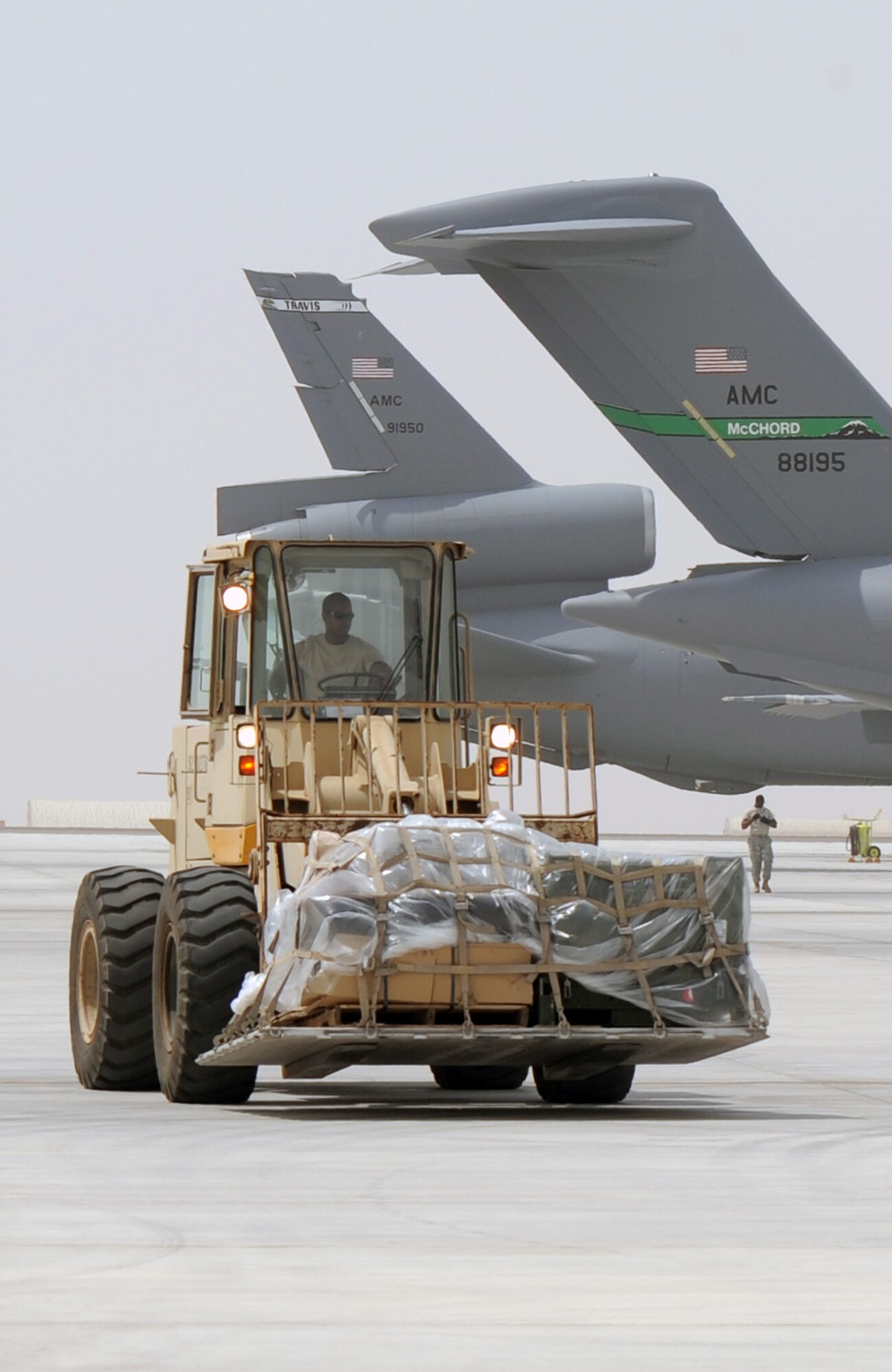 An air transportation Airman from the 380th Expeditionary Logistics Readiness Squadron's Air Terminal Operations Center drives an extreme-terrain forklift carrying a pallet of cargo for a C-17 Globemaster III during operations on the flightline for the 380th Air Expeditionary Wing at a non-disclosed base in Southwest Asia on March 27, 2010. All of the air transportation Airmen with the 380th ELRS are deployed from the 89th Aerial Port Squadron at Joint Base Andrews, Md. The 380th AEW supports operations Iraqi Freedom and Enduring Freedom and the Combined Joint Task Force-Horn of Africa. (U.S. Air Force Photo/Master Sgt. Scott T. Sturkol/Released)