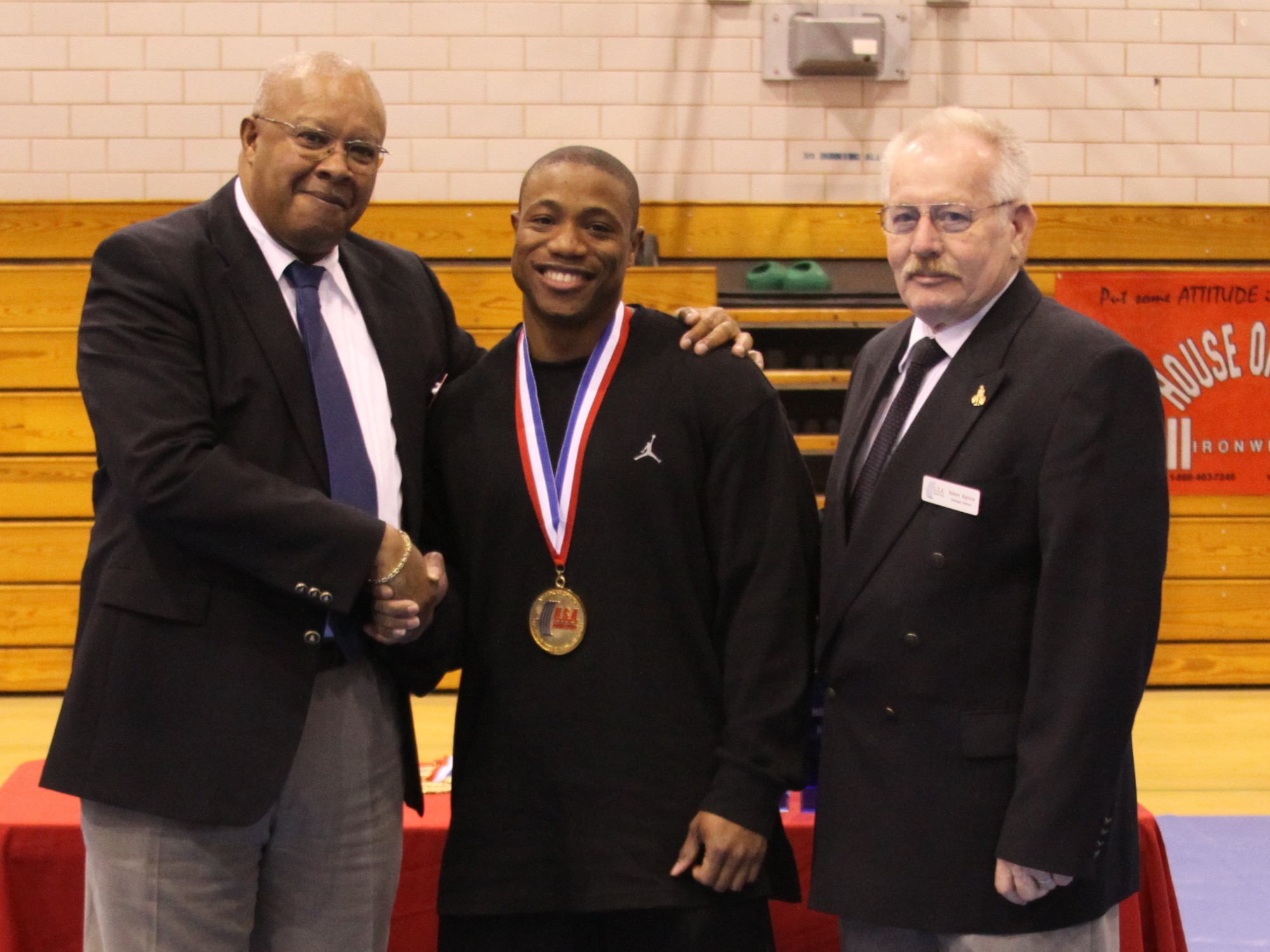 Tech. Sgt. Kenyatta Wilson - Unit Training Monitor with the 65th Communications Squadron, with the Military Nationals officials after winning a gold medal during the powerlifting competition.