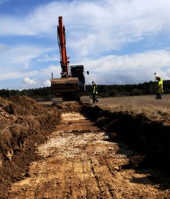 RAF MILDENHALL, England – Robert Brooks and Mike Feider, Suffolk County Council archaeology service, oversee an exploratory archaeological March 26.  Long trenches are dug to remove topsoil so that excavators can see if further excavation is needed.  (U.S. Air Force photo/Staff Sgt. Christopher L. Ingersoll)