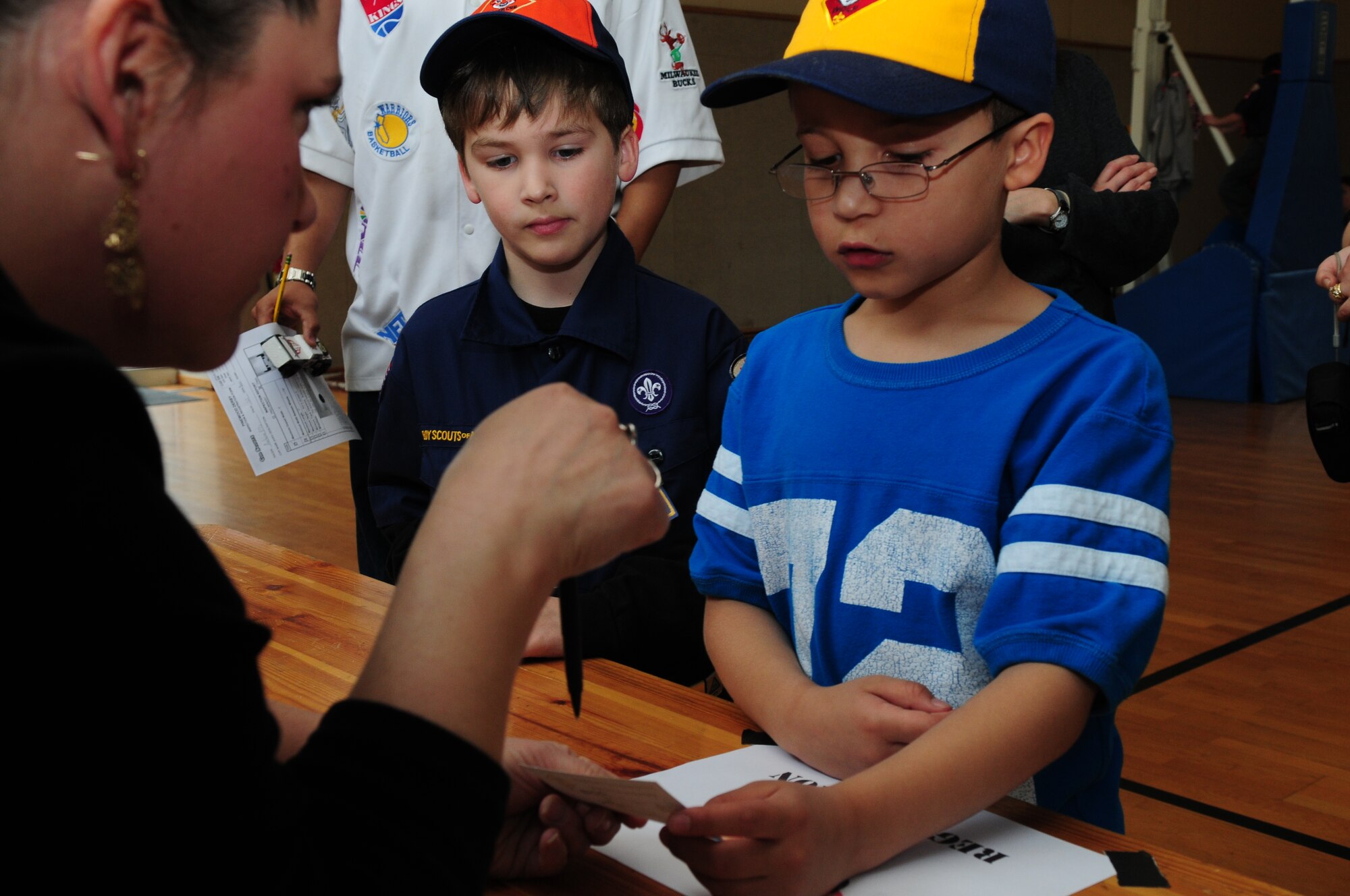 BITBURG ANNEX, Germany -- James Marrs, right, receives his license while Jacob Gregg, center, looks on March 27.  The license permits them to race their cars in the annual Pinewood Derby. (U.S. Air Force photo/Staff Sgt. Heather M. Norris)